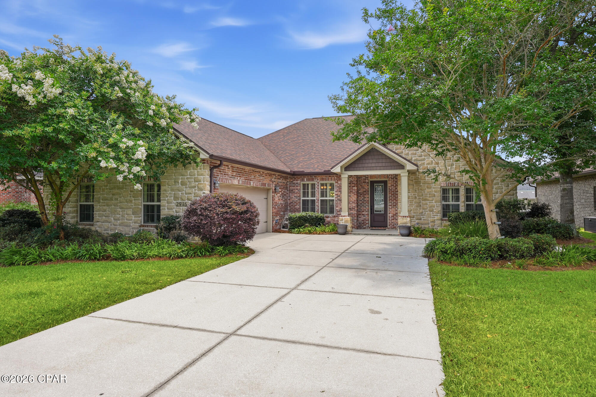 Offering 2,938 square feet of well-appointed living space and soaring ceilings, this thoughtfully designed 4-bedroom, 3.5-bath custom Hawks Landing home showcases enduring style, generous proportions, and a highly functional open-concept floor plan. With all four bedrooms conveniently located on the main level and a versatile upper-level flex space above the garage, the home delivers both everyday comfort and remarkable adaptability to complement modern lifestyle needs.

The impressive main living area is anchored by an elegant tray ceiling, custom built-ins, wood floors, and a gas fireplace, creating an inviting atmosphere that feels elevated, polished, and effortlessly livable. Designed for everyday living and entertaining, the spacious Chef's kitchen serves as the heart of the home--featuring granite countertops, rich wood cabinetry, stainless appliances, double ovens, a large center island with breakfast bar, and a sunny breakfast nook overlooking the backyard. The adjoining oversized screened porch creates a seamless indoor-outdoor living experience, perfect for morning coffee, cheering on your favorite teams, enjoying movie nights, taking in stunning sunsets, or unwinding with an evening drink.

Privately situated within the split-bedroom floor plan, the substantial primary suite offers a peaceful retreat with a beautiful tray ceiling and French doors providing direct access to the covered back porch. The roomy en-suite bath includes two walk-in closets, a double vanity, a jetted soaking tub, separate tiled shower, and private water closet.

The formal dining room, accented by an exquisite, coffered ceiling and plantation shutters, provides versatility for special occasions, a home office, or an additional gathering area. All secondary bedrooms are generously sized with ample closet storage and ceiling fans.

Upstairs, the bonus room with a private half bath and separate thermostat provides a dedicated area for a media room, guest quarters, home gym, playroom, or fifth bedroom.

Outside, the expansive fenced backyard offers exceptional space for recreation, relaxation, and hosting guests. Complete with a convenient gas stub for an outdoor grill, the covered porch extends your living space and creates the perfect setting for outdoor dining and year-round gatherings.

Significant recent improvements include a new roof (2019), HVAC system (2021), carpet (2023), innovative ''on-demand tank'' water heater (2024), and stainless-steel kitchen appliances that are all less than three years old.

Additional features include an oversized two-car garage with additional hobby/workshop space, laundry room with utility sink and tailored storage cabinetry, irrigation system, seamless gutters, and enhanced exterior doors from the kitchen, primary suite, and third full bath to the covered and screened porches with integrated between-the-glass blinds, offering convenient privacy and custom light control.

Hawks Landing is a desirable planned community offering a welcoming neighborhood setting with custom-style homes, inviting sidewalks ideal for neighborhood strolls, and a central location with convenient access to Tyndall Air Force Base, Naval Support Activity Panama City, hospitals, and other major employers, as well as top local schools. Residents also enjoy close access to recreation and everyday amenities, including the Lynn Haven Sports Complex, Deer Point Lake, nearby shopping and dining, multiple golf courses, and the sugar-sand beaches along the nearby Gulf Coast.

This move-in-ready and beautifully maintained home combines timeless design, modern enhancements, and adaptable living options suited for every stage of life. Whether you're entertaining, working from home, or simply enjoying everyday life, you'll appreciate its versatility today and for years to come. 

An added opportunity for qualified VA buyers with available VA entitlement: the Seller's existing 3.625% VA loan may be assumable!