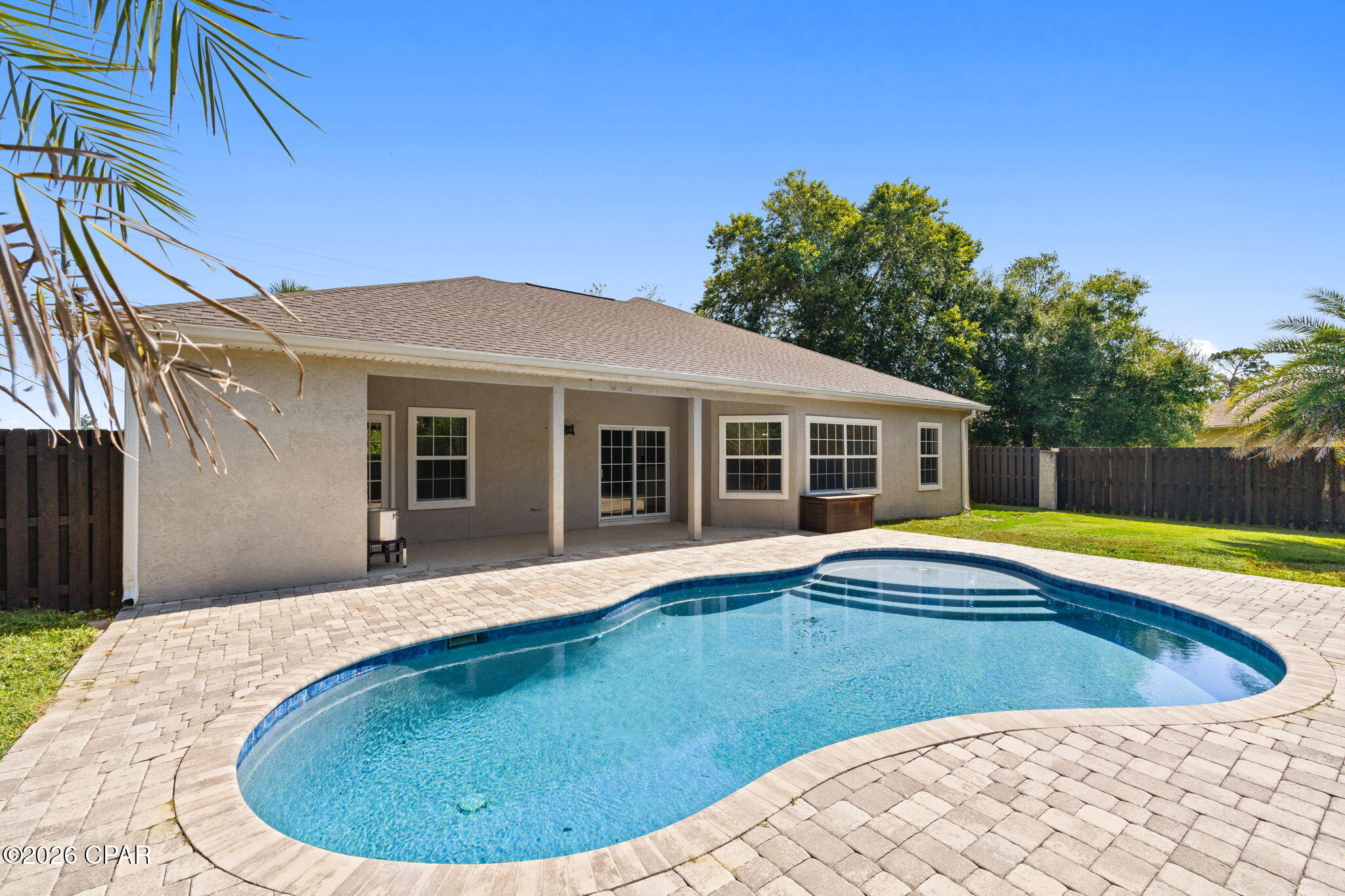 Welcome to this beautifully maintained 3-bedroom, 2-bath home in the desirable Magnolia Point at The Preserve! Offering comfortable single-level living, this home combines thoughtful updates with an exceptional outdoor retreat. Inside, you'll find a spacious living room centered around a cozy gas fireplace, a formal dining area, and a generous kitchen featuring a breakfast bar and adjoining breakfast nook, perfect for everyday living or entertaining. The oversized primary suite offers waterproof composite flooring, a large walk-in closet, an en-suite bath with a whirlpool tub and separate shower, plus private access to the backyard.
Step outside to your own private oasis featuring a stunning saltwater pool installed in 2021, a large covered patio, and a fully fenced backyard designed for relaxing, entertaining, or enjoying Florida's beautiful weather. Major updates provide peace of mind including a 2025 Hisense high-efficiency HVAC system, 2020 roof, 2020 gas water heater, 2025 pool pump, and numerous newer appliances including the refrigerator and range (2021), dishwasher (2024), washer (2025), and dryer (2021).
Conveniently located just minutes from the Navy base, marinas, shopping, dining, and the white sandy beaches of Panama City Beach, this move-in-ready home offers the perfect blend of comfort, convenience, and Florida living.