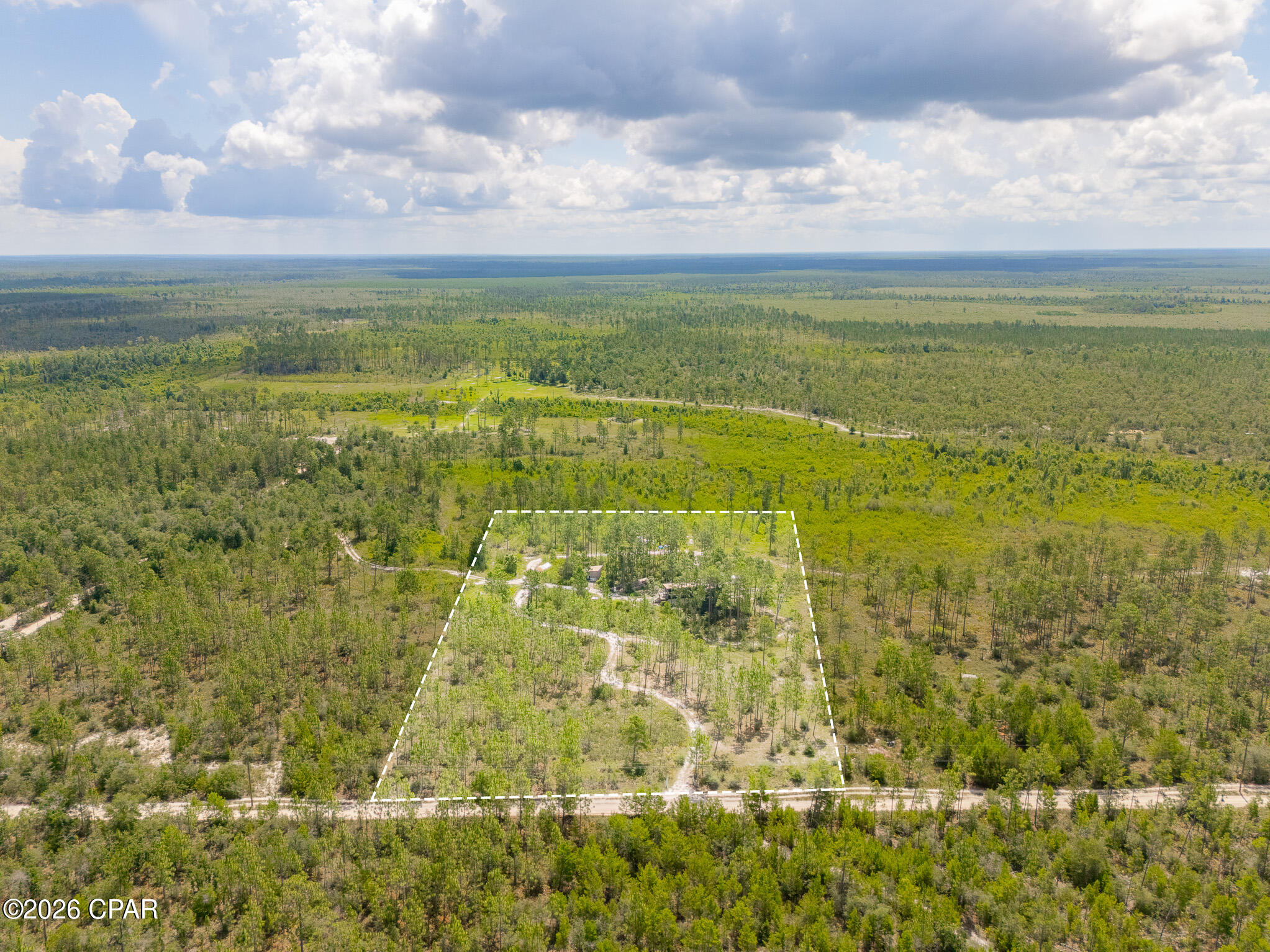 Escape to your own private retreat on this beautiful property tucked away at the end of a quiet dead-end road. Offering the perfect balance of cleared land and mature pine trees, this property provides exceptional privacy, abundant wildlife, and endless possibilities for outdoor enthusiasts, hunters, or anyone seeking a peaceful homestead.

The property features a wrap-around driveway, fencing along the front and right property lines with two farm gates at the entrance, and two separately fenced yard areas. One fenced yard surrounds the main structure, while the second includes a shelter ideal for livestock, equipment storage, or other agricultural uses. A chicken coop and small animal pen are already in place, making this property ready for your hobby farm.

Nature lovers will appreciate the abundant wildlife, including deer, turkey, coyotes, birds, and even the occasional bear. Enjoy beautiful sunrises and sunsets from your own secluded oasis with plenty of shade and dry land throughout the property.

The main residence is an 18' x 32' elevated off-grid cabin, thoughtfully designed with comfort and efficiency in mind. Features include:  Solar-powered electrical system with 5.2 kW solar array and 800 amp-hour battery storage. Running water with an 800-gallon water storage system, filtration, and pump. Propane-powered tankless hot water heater and Full bathroom.
One bedroom with double closets, overhead storage, and French doors leading outside
Beautiful live-edge cedar finishes throughout, including a custom cedar bar, 13-foot live-edge mantel with shelving, and cedar window sills
Brand-new LVP flooring, fresh paint throughout and LED lighting. Enclosed storage beneath the cabin perfect for a workshop, equipment, or additional storage.
Built elevated approximately 8 feet off the ground on heavy-duty beams

A second 12' x 16' building with loft offers additional flexibility and includes solar power. Use it as a workshop, powered storage building, guest space, office, or finish it into a tiny home.

Additional highlights include:
Electricity available at the front of the property if desired. Approximately ½ mile down a maintained sugar sand road (4WD recommended). Only a handful of neighboring properties beyond this location.
Peaceful setting with exceptional privacy
Ideal for hunting, recreation, homesteading, or weekend getaways

If you've been searching for a secluded property that's already equipped for off-grid living while offering room to grow, this unique opportunity is one you won't want to miss. Schedule your private showing today!