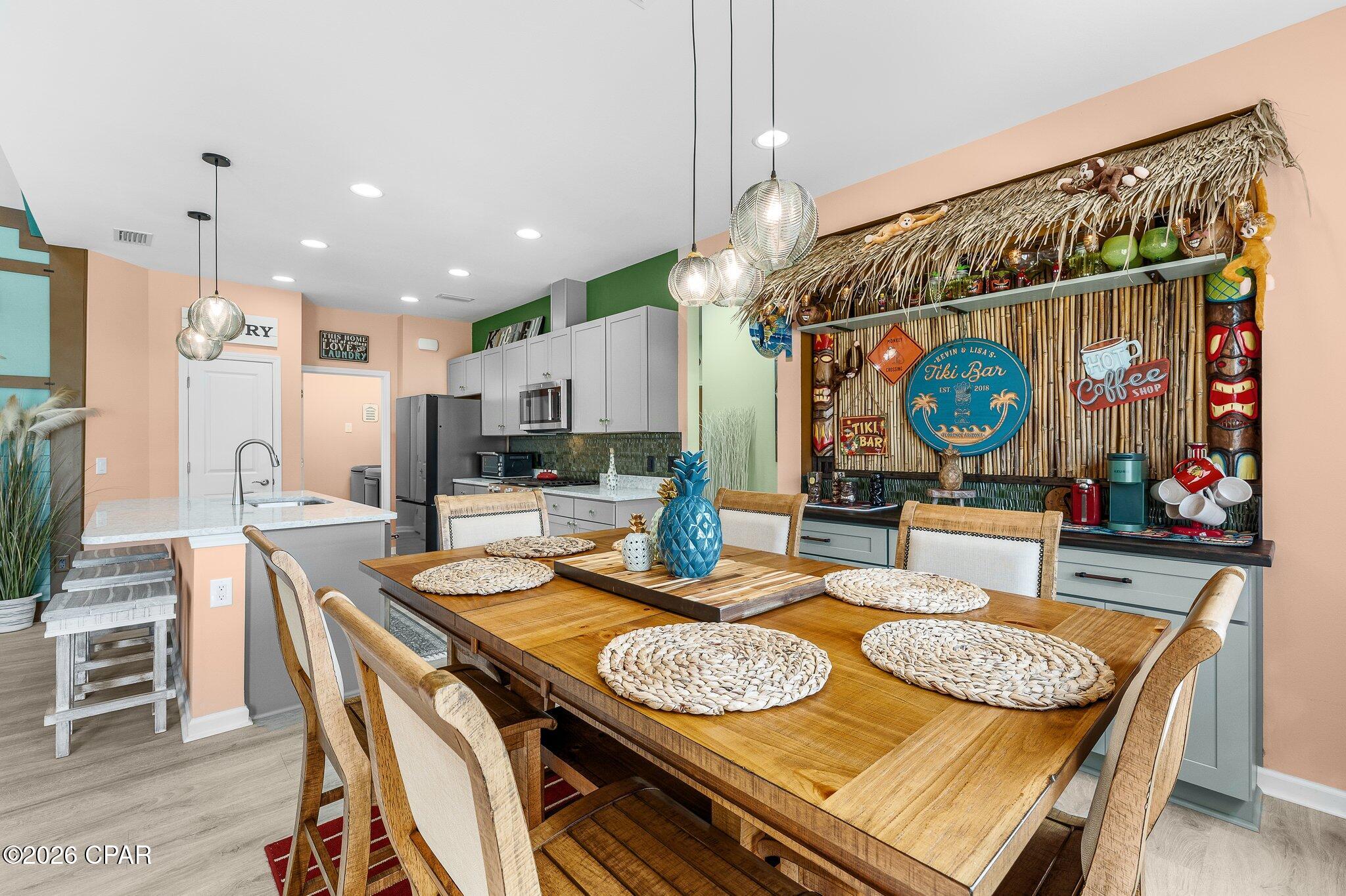 Upgraded Coastal Dreamsicle Cottage with Intracoastal Views & Flex Room!
Welcome home to this stylish, street-facing Dreamsicle model, elegantly upgraded and located in the highly desirable 55+ Latitude Margaritaville Watersound community. Offering the ultimate ''vacation every day'' lifestyle, this beautiful Florida cottage shines with vaulted and 9-foot ceilings, custom tropical paint, and upgraded luxury vinyl plank flooring throughout the main living areas. The open-concept layout features a grand living room with vaulted, beamed ceilings and recessed lighting, creating a bright and airy atmosphere. Just off the main living space, a versatile flex room with elegant glass doors offers the perfect footprint for a private home office, den, or hobby space. The gourmet kitchen is a chef's dream, fully equipped with upgraded grey soft-close cabinetry, premium Cambria Kendal Quartz countertops, and high-end KitchenAid stainless steel appliances. Perfect for entertaining, the adjacent dining room boasts a custom Tiki Coffee Bar with a stylish backsplash and soft-close drawers.  Every window is finished with elegant aprons and custom Roman shades. Additional high-value upgrades include Decora switches throughout, a screened-in porch perfect for everyday relaxation, and a fully finished garage featuring epoxy flooring, overhead storage racks, and a utility sink. Situated on a premium lot, this home allows you to kick off your flip-flops, look out toward the Intracoastal Waterway, and enjoy breathtaking Florida sunsets from your own piece of paradise.