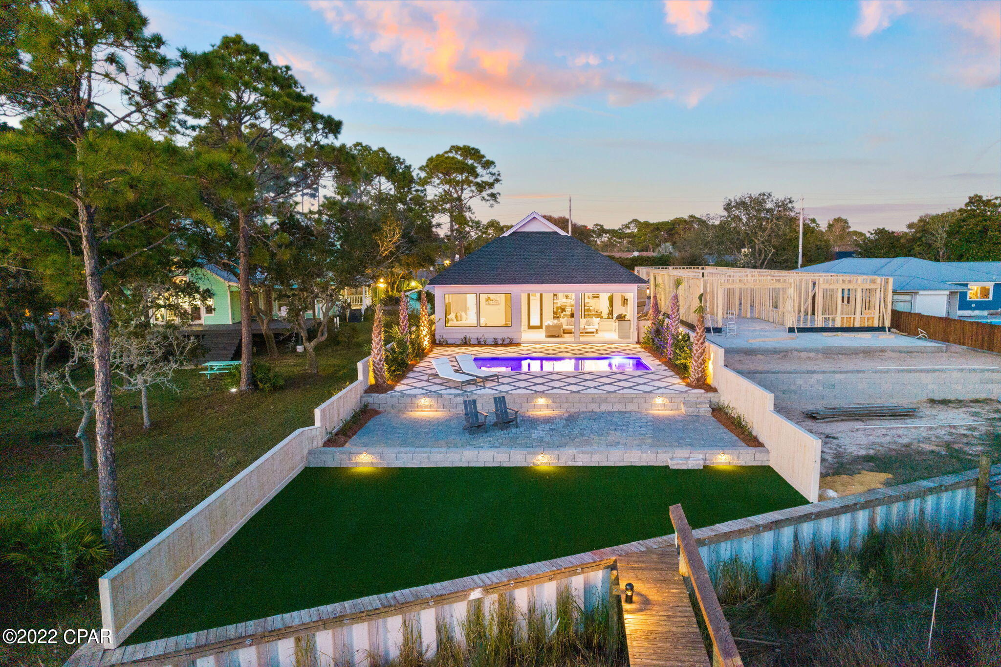 Live the waterfront Florida lifestyle that many dream of experiencing and enjoy a lucrative investment opportunity with this immaculate New Construction Waterfront home located at 8747 N Lagoon Dr. Boasting rental projections of $150,000-$170,000, this home is sure to exceed your expectations. From the moment you step into this stunning home, you will be blown away by the large open floor plan and architectural design that captures natural light and brings the outdoors in beautifully.

All of the living spaces have been thoughtfully designed with attention to detail, including the best and finest materials, such as soaring 20ft ceilings in the main living area, hardwood flooring, a neutral color palette, and designer lighting. An entertainer's paradise, the stunning gourmet kitchen is the focal point, featuring stainless steel appliances, and a large walk-in pantry.
The water-facing primary suite is like something out of a magazine, with a spa-inspired design, a large walk-in closet outfitted with a washer/dryer, and custom built-in cabinetry. Enjoy your spacious outdoor living space with Peacock paver pool deck surrounding the large underground 16'5"x26' pool, Lanai, and outdoor bbq. The outdoor areas of this home are designed to offer that tranquil and secluded space all buyers crave while being idyllic to unwind or entertain guests. A true boaters paradise this home comes complete with a 15'x32' covered boat slip. This home also features a two-car garage with enough space for a golf cart, beach toys, etc.
Premier placement within the neighborhood creates privacy while still allowing easy access to Panama City Beach hot spots. Conveniently located a short distance from Pier Park and 30A leaves you minutes away from some of the Panhandle's best shopping and dining experiences. Don't miss out on this exceptional investment opportunity. *** All information and dimensions are to be verified by the buyer.