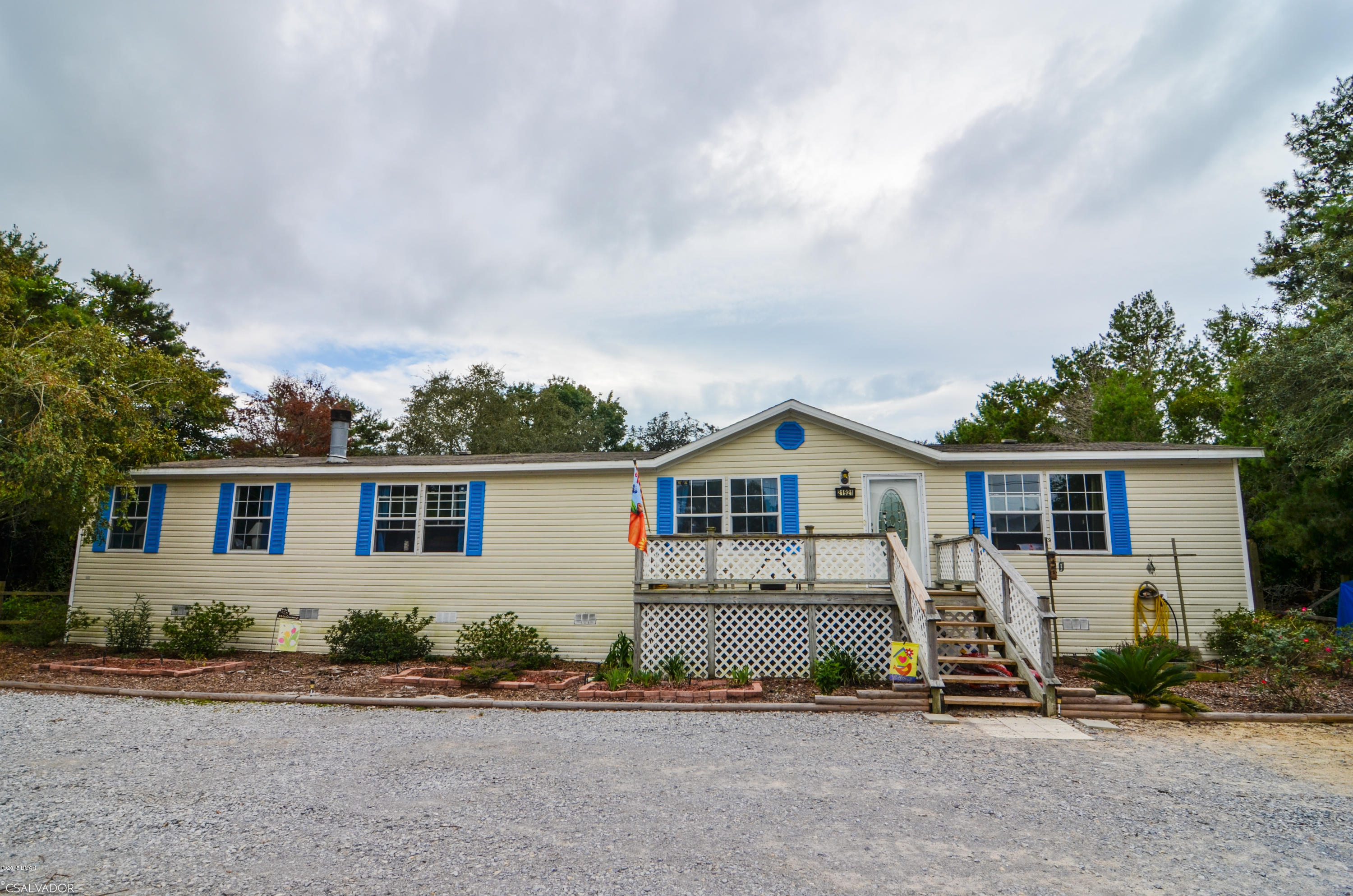 Great opportunity on the West-End of Panama City Beach; right across from Lake Powell.  Large 2160 sq. ft. 1999 Double Wide in excellent condition, featuring cathedrial ceilings, double door refrigerator, dishwasher, stove, jacuzzi tub and a rock fireplace, all on a FULL 82'x150' lot, with a view of Lake Powell!!!! Own and live here, or use as an excellent rental. Then in the future build your dream home on this beautiful lakeview lot!!!!!