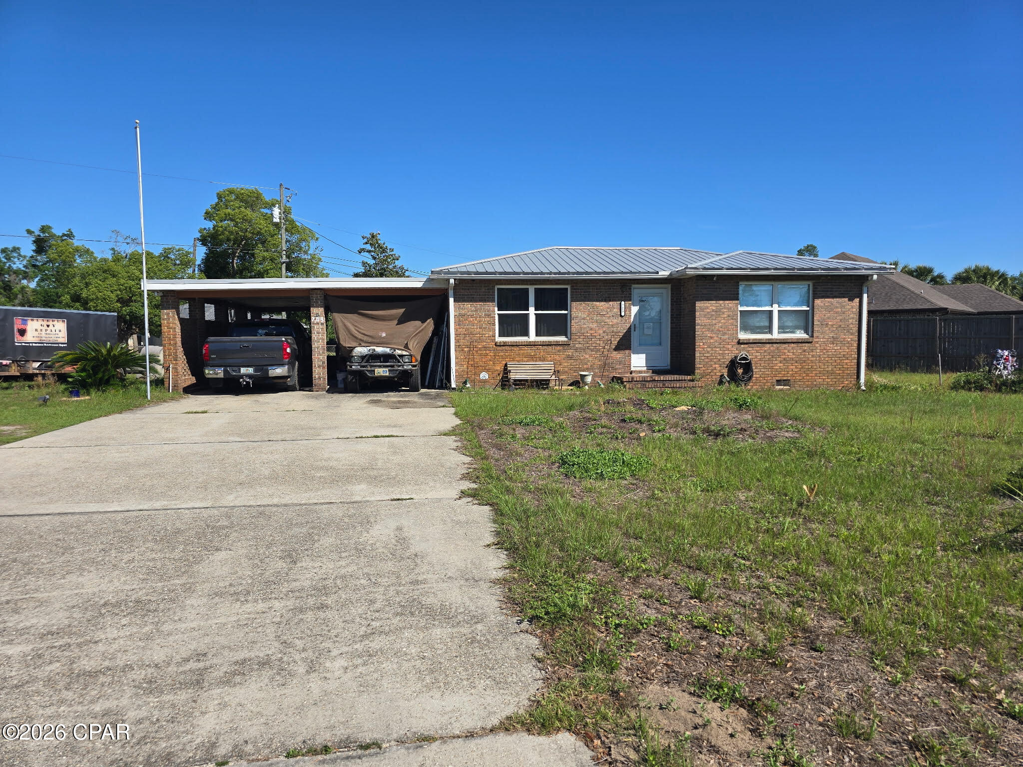 This brick home on large lot sits right across from the bayou.  The home had a new metal roof put on after the hurricane along with all new windows in the house.  The house is a 3/2 with living room and den.  The den and master bedroom was built in the 1970's and the walls are the knotty pine in those rooms.  The original part of the home still has the hardwood floors and might can be refinished.  This is a fixer upper and is being sold as is.  There is a new water heater in the kitchen.  The house has an attached two car carport with a storage room.  One side of the carport can be a drive through.  There is also an additional building which houses a one car garage and large workshop.  The laundry room is out here too.  The lot is set up so that you can enter from 8th Street or the drive on the side street Iowa.  There are also double gates in the backyard to drive into the garage from the Iowa side.  This home needs work on the inside but could be turned into a great rental investment property or a flip.  The homes in the area are all being updated and this lot could be turned into something fantastic.  It is a quick sale, need short inspection period and a quick cash closing.  Bring your offer and start the adventure!