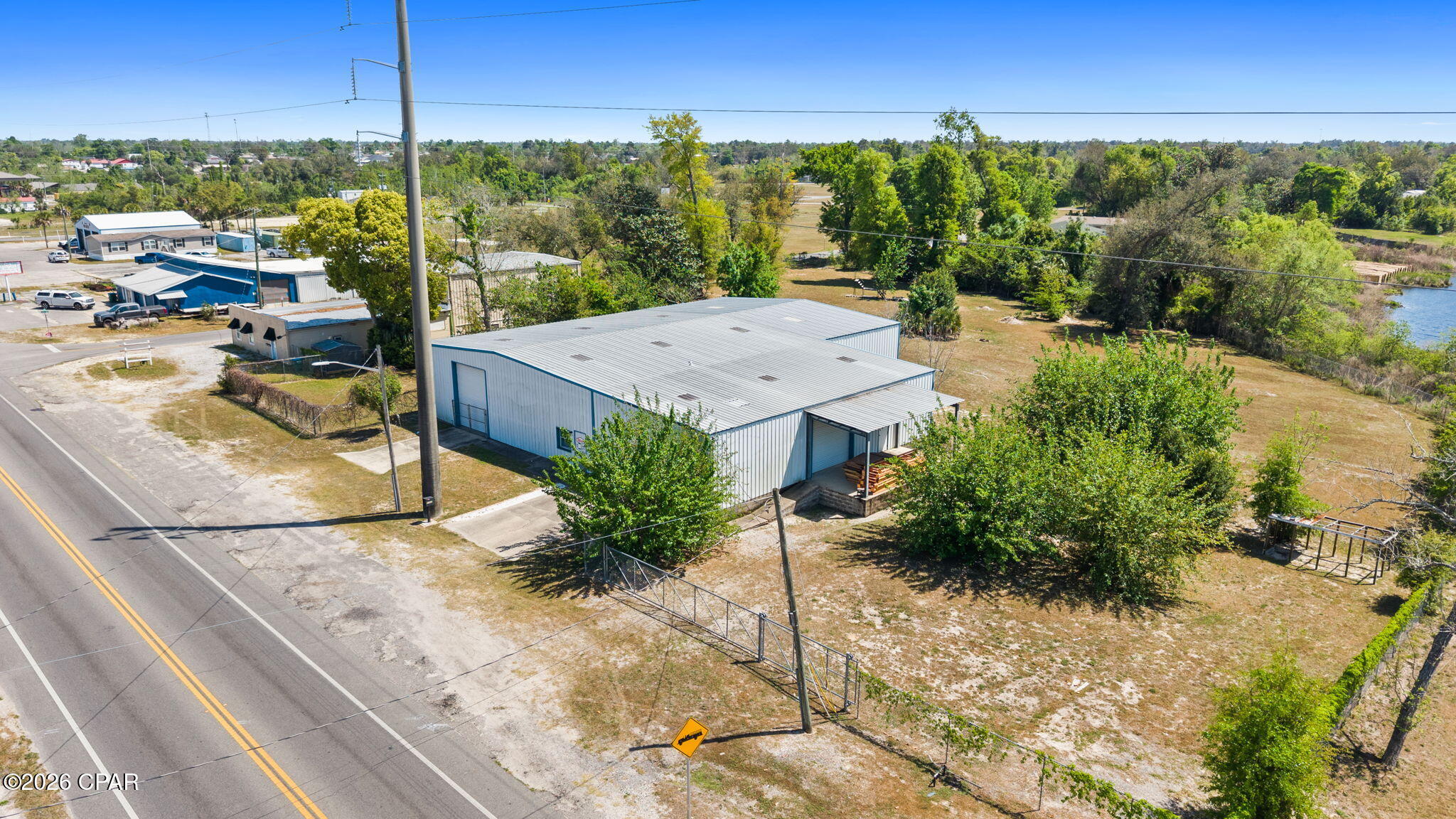 2.35 ACRES | MIXED-USE ZONING | LARGE WAREHOUSE OPPORTUNITY NEAR TYNDALL AFB - Positioned on the east end of Bay County, this offering includes two parcels totaling approximately 2.35 acres of mixed-use property. The fully fenced site features dual ingress and egress points, allowing for smooth traffic flow and operational efficiency.

The property is anchored by a well-constructed 7,600 SF warehouse (see floor plan in documents) equipped with dock-high loading, two 14' roll-up doors, two 10' roll-up doors, drive-in access, and pull-through capability exiting onto N Claire Ave.--ideal for logistics, distribution, or service-based operations.

An expansive yard provides ample laydown and maneuvering space, perfect for equipment, fleet, or contractor use, all within close proximity to Tyndall Air Force Base for added strategic value.

Zoned mixed-use, the property offers a wide range of potential uses--buyers are encouraged to contact Springfield's City Clerk for specific allowable uses and development opportunities.