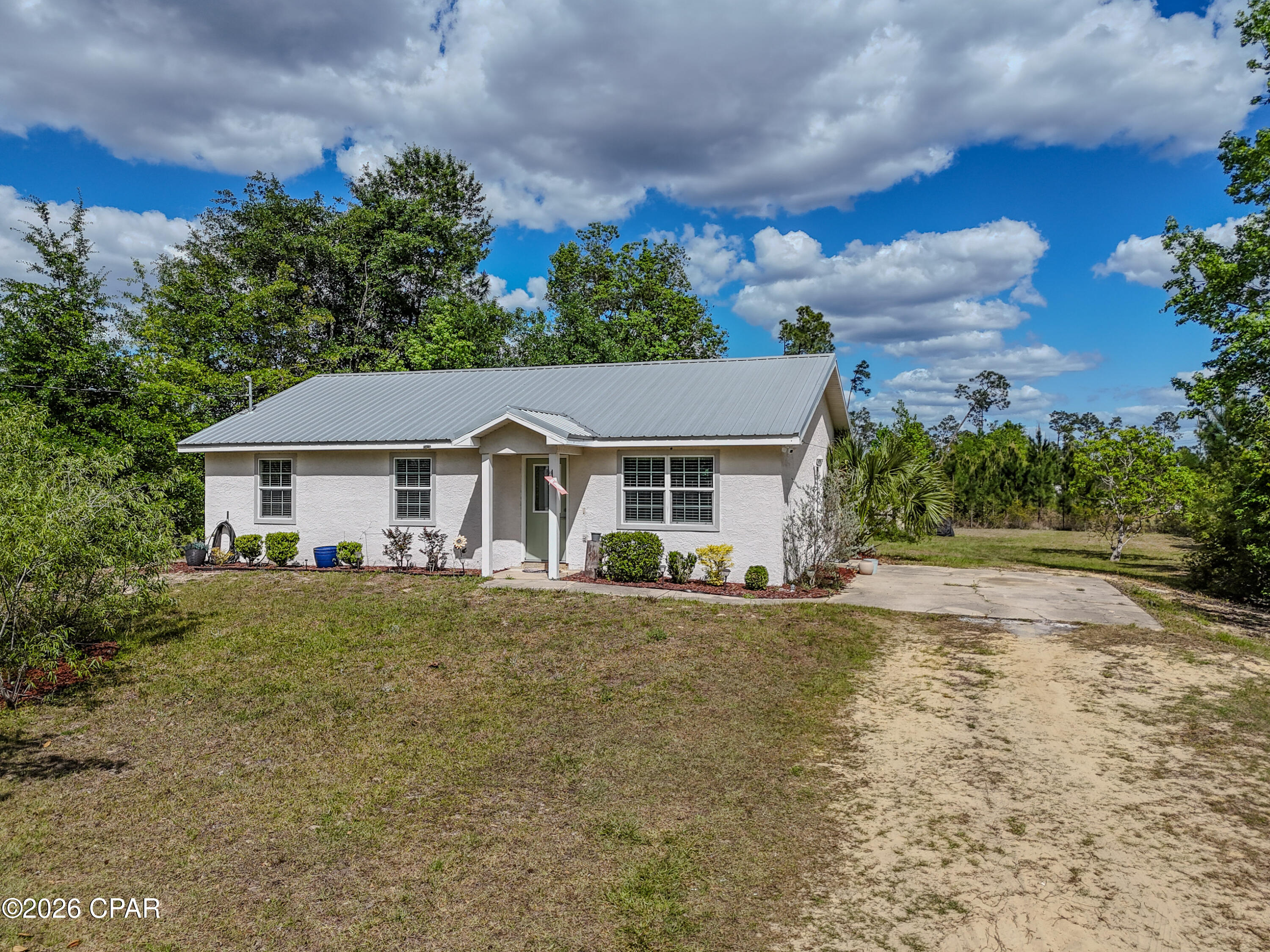 CURRENTLY UNDER CONTRACT, SELLER WILL CONSIDER BACKUP OFFERS
Conveniently located just off Highway 231 in Panama City, this property offers easy access to dining, shopping, and grocery stores, while still providing a peaceful setting just outside of town. Enjoy a short drive to Tyndall Air Force Base and the beautiful beaches of Panama City Beach, all while experiencing the tranquility of a quiet, no-HOA neighborhood. This spacious three-bedroom, two-bathroom home features an open-concept living and dining area designed for both comfort and functionality. The kitchen offers ample cabinet space along with stainless steel appliances, including a stove, microwave, and dishwasher. A conveniently located guest bathroom provides easy access for visitors and daily living. The well-appointed bedrooms offer plenty of space, highlighted by a large primary suite complete with a walk-in closet and private en-suite bathroom.
This well-maintained stucco home has been thoughtfully updated and features a freshly painted interior, including doors and trim, creating a clean, move-in-ready f, including insulation, drywall, ceilings, lighting, and flooring, countertops, and a durable metal roof in 2019, the well and septic system were replaced in 2022, and a new hot water heater was installed in April 2026, offering peace of mind for years to come.
Situated on nearly one acre, the property provides plenty of room to enjoy the outdoors and includes a playground and a utility building equipped with underground power and soundproof insulation, perfect for a workshop, hobby space, or additional storage. Seller is offering up to $7,500 toward buyer's closing costs with an acceptable offer, providing an excellent opportunity to reduce out-of-pocket expenses and make homeownership even more attainable.