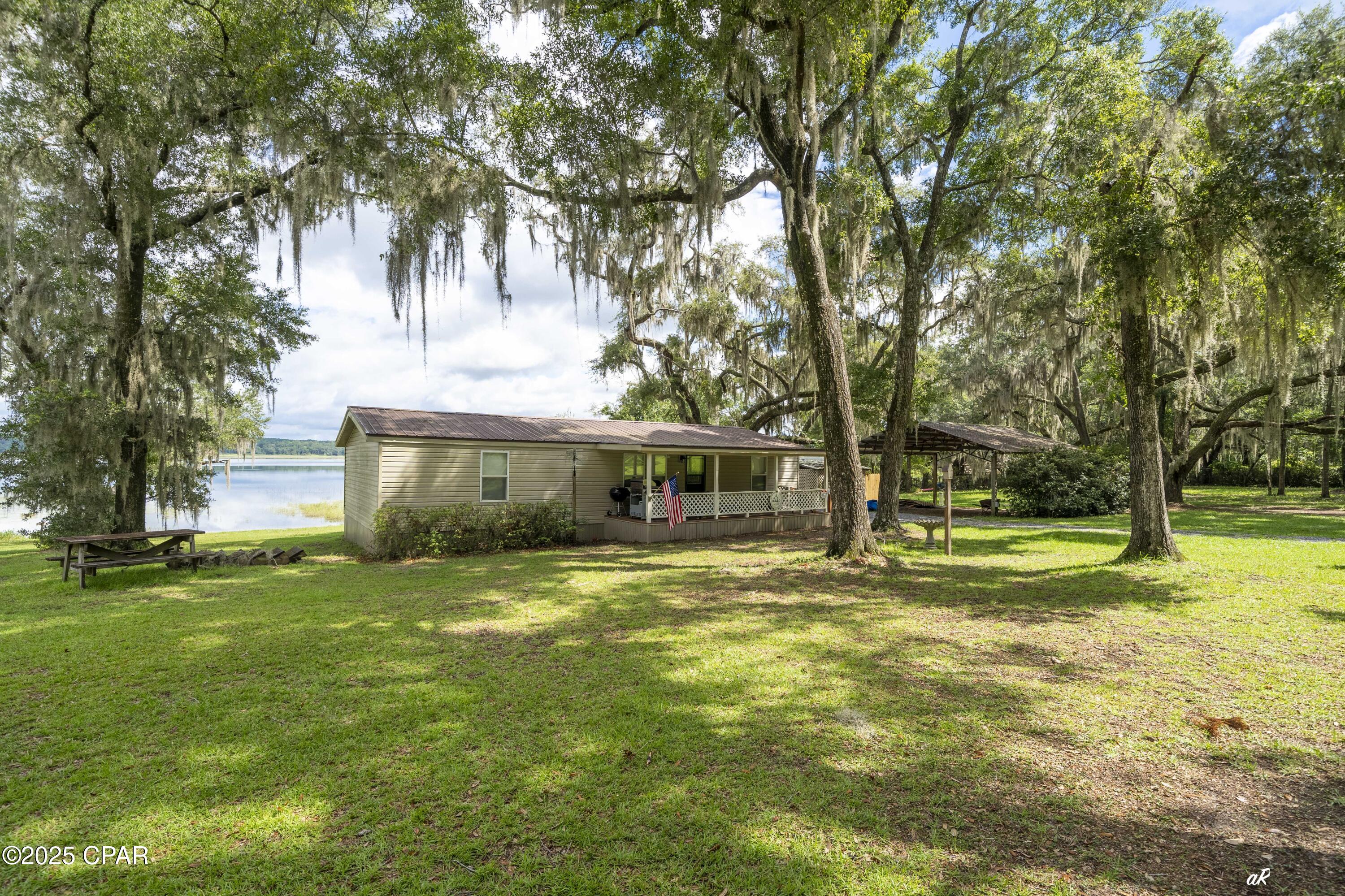 HICKS LAKE (POND) near Chipley, FL.  Are you craving a weekend escape from the hustle and bustle of city life?  Or maybe you're an avid angler in search of the perfect fishing spot?  Look no further!  Hicks Lake is a serene location that offers a peaceful retreat for nature lovers and outdoor enthusiasts.  The lake is 485 Sq Acres and is surrounded by lush greenery, providing a picturesque setting for activities such as fishing, swimming, birdwatching, boating, jet skis or simply enjoying the scenic views.  You can also engage in water sports like paddleboarding, kayaking, and paddle surfing, making Hicks Lake a perfect spot for outdoor adventures and relaxation.  The area is also known for its tranquil atmosphere, making it an ideal location for a quiet reflection or a rejuvenating outdoor experience. Only 45 minutes to Panama City Beach, FL and 15 minutes to Chipley, FL.  Remodeled 1989 24' x 72'manufactured home with 3/2 and 1,152 SF of living area with 2 large-covered porches.  Back porch is facing lake and is 12 x 30.  It's an awesome place to enjoy those panoramic lake views.    Outside has a 24 x 24 pole barn with separate storage building with outside sink and shower.  Also, has a deep submersible well ... additionally has a 30 amp RV power hookup.  For convenience seller's launch their boat from lakeside.  As a bonus you can go across street to boat launch and be in Lucas Lake.  Call today for private showing! MOTIVATED SELLER ... BRING REASONABLE OFFER!