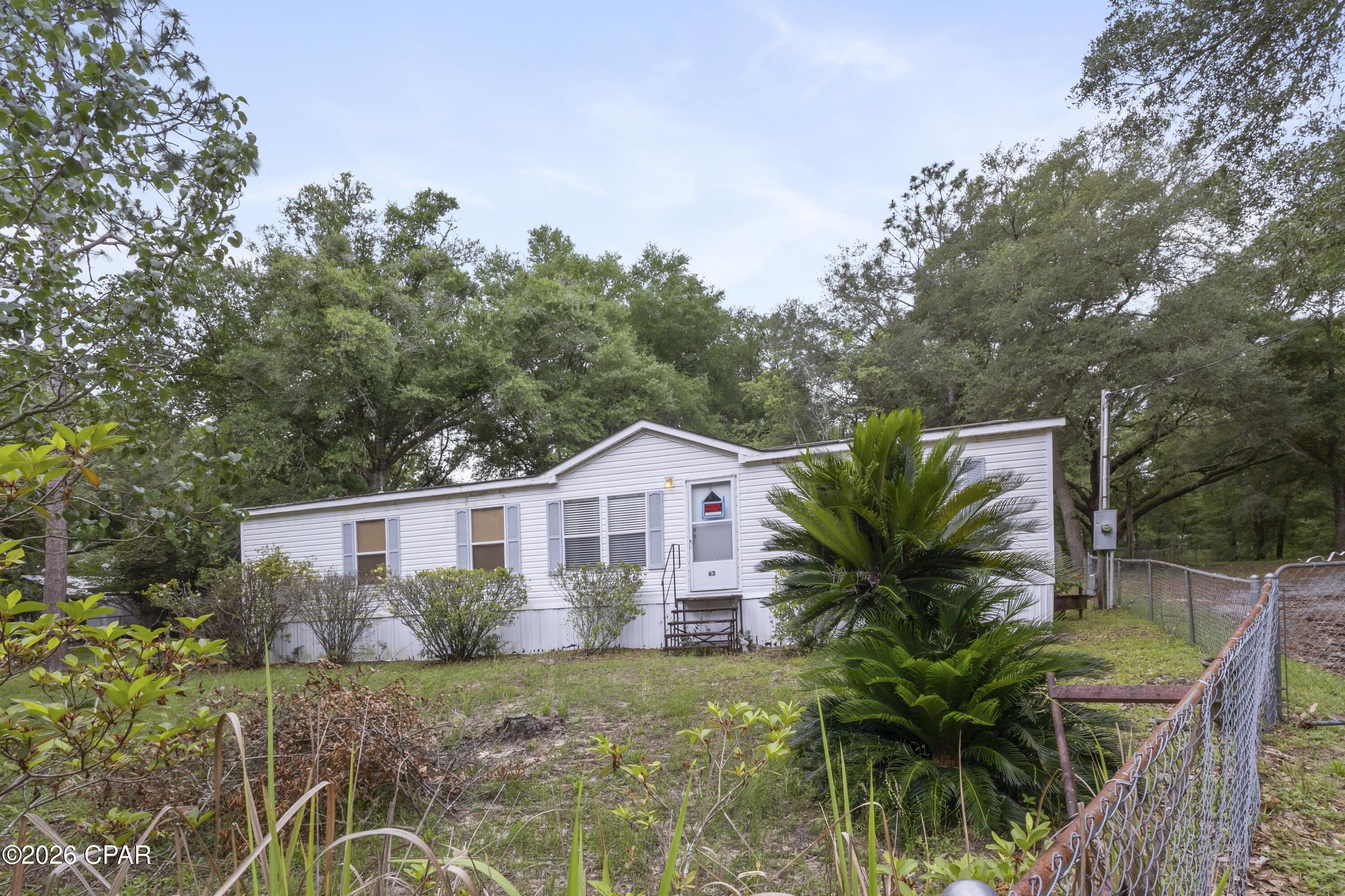 Rare opportunity near Juniper Lake with two adjoining parcels totaling approximately 1.05 acres. The main residence at 63 Cherokee Circle offers a 3-bedroom, 2-bath doublewide with a split floor plan, spacious living area, eat-in kitchen, covered back porch, fenced yard, and plenty of shade from mature trees. Updates include a newer roof, updated A/C, refreshed interior paint, updated bathrooms, stainless appliances, and new carpet in the primary bedroom.