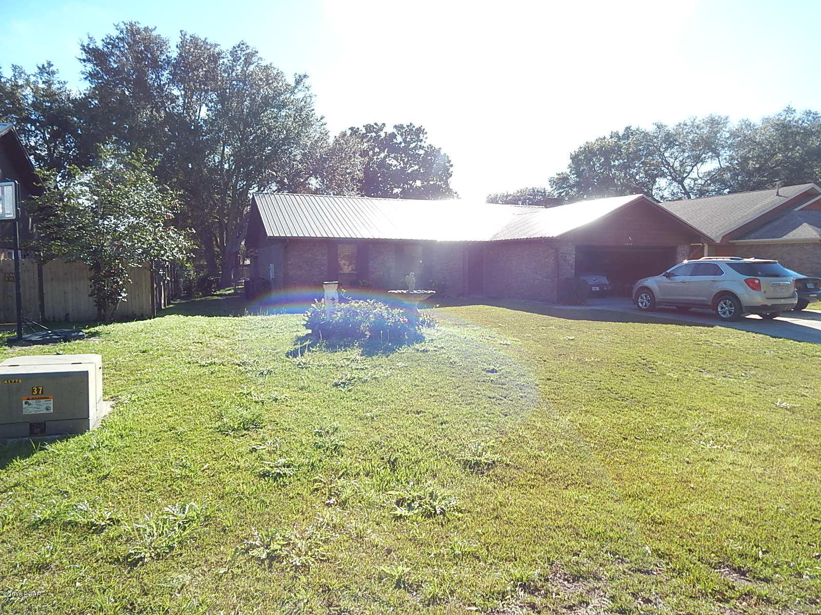 All Brick home on large shaded lot just minutes to Tyndall AFB and shopping. This home was built by Paul Sims for the original owner. According to the Sellers family Dad built this home to last with lots of internal building upgrades. This home represents an excellent use of space. Very nice Great Room with Vaulted Ceilings with a oversized wood burning fireplace as the focal point. Great Room is open to the kitchen and Breakfast nook area. Before mom went into care facility all new Ceramic Tile floors were added. Permitted Metal roof installed about a year ago. And wonderful tiled Florida Room overlooking the shaded back yard. Dad put a Deep Water Well for back up to city water, and a shallow Lawn water well. Awesome Yard. The home Needs some cosmetic updating but price to sell.