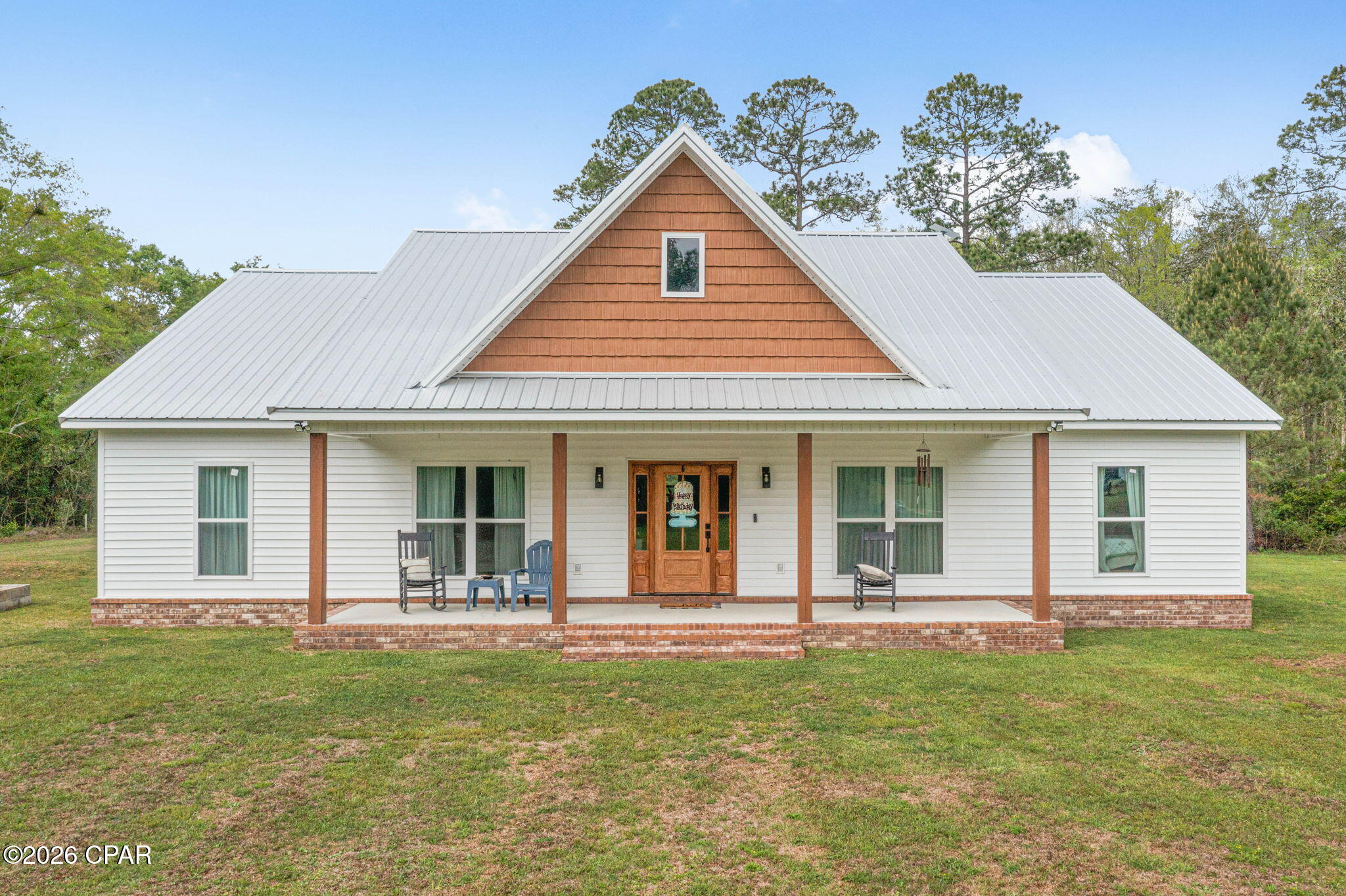 Welcome to this beautifully designed 3-bedroom, 2-bath home set on 6.19+/- acres, offering the perfect blend of modern farmhouse charm and peaceful country living. From the moment you step inside, you'll love the open-concept layout featuring vaulted ceilings with exposed wood beams, a stunning shiplap fireplace wall, and custom built-in shelving that creates a warm and inviting focal point. The kitchen is a true standout, offering a large island with seating, stainless steel appliances, custom cabinetry, and a gorgeous vent hood that adds character and style. Just off the kitchen, a spacious walk-in pantry provides plenty of storage and organization. The split floor plan offers privacy, with a spacious primary suite featuring a spa-like bathroom complete with dual vanities, custom tiled shower, and an oversized walk-in closet. Two additional bedrooms and a full bath are located on the opposite side of the home, perfect for family or guests. Additional features include a well-appointed laundry room with cabinetry and workspace, durable vinyl plank flooring throughout, and thoughtfully designed finishes in every room. Step outside to enjoy the covered front porch overlooking your private setting. The outdoor space is ready for both relaxing and entertaining with a firepit area, and a 32x60 open pole barn with 5 bays--perfect for equipment, vehicles, or hobbies. If you've been searching for space, style, and a quiet country setting with convenient access to nearby areas, this property checks all the boxes.