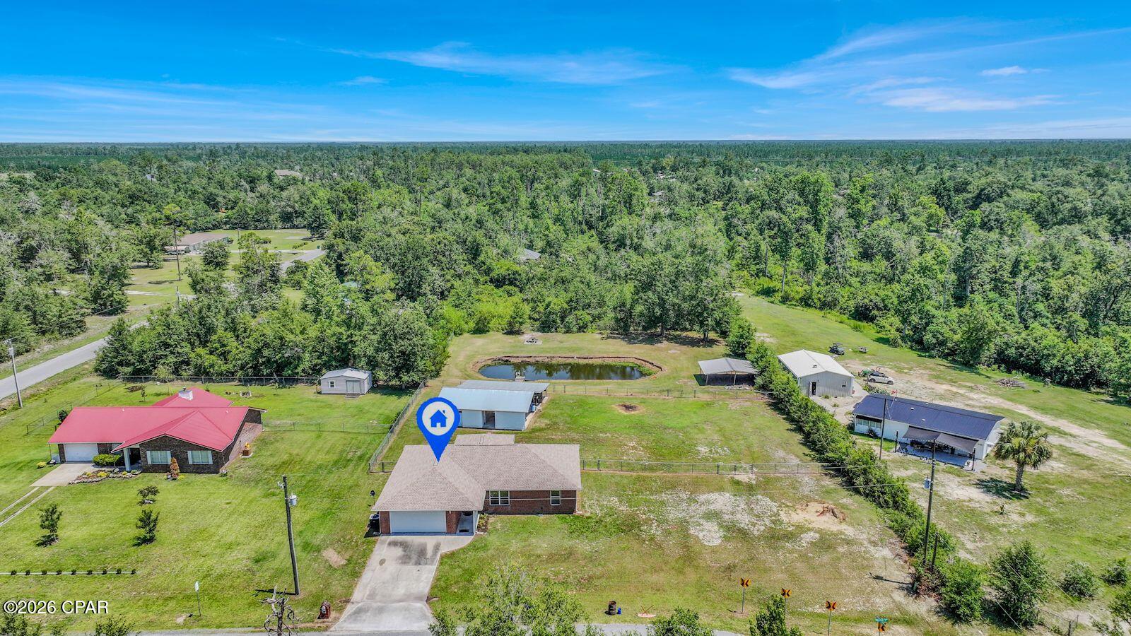 If you've been searching for a property with space, freedom, and versatility, this 3-bedroom, 2-bathroom home checks all the boxes. A huge perk is the brand new roof that was just added in spring 2026. Situated on 1.1 acres in Bay County, this property offers a rare combination of a private pond, a large pole barn complete with its own bathroom, and no HOA restrictions, giving you the flexibility to store your boats, RVs, equipment, or create the workshop you've always wanted.

Inside, you'll find a desirable split-bedroom floor plan designed for privacy and everyday comfort. The spacious living areas provide plenty of room for gathering with family and friends, while the primary suite is tucked away from the guest bedrooms for added privacy.

Enjoy peaceful mornings overlooking the pond, afternoons working on projects in the pole barn, and evenings relaxing on your own piece of Bay County paradise. All of this is conveniently located just 10 minutes from Lynn Haven, offering the perfect balance of country living with easy access to shopping, dining, schools, and everyday conveniences.

Properties offering acreage, a pond, a pole barn, and no HOA are hard to find, don't miss your opportunity to make this one yours.