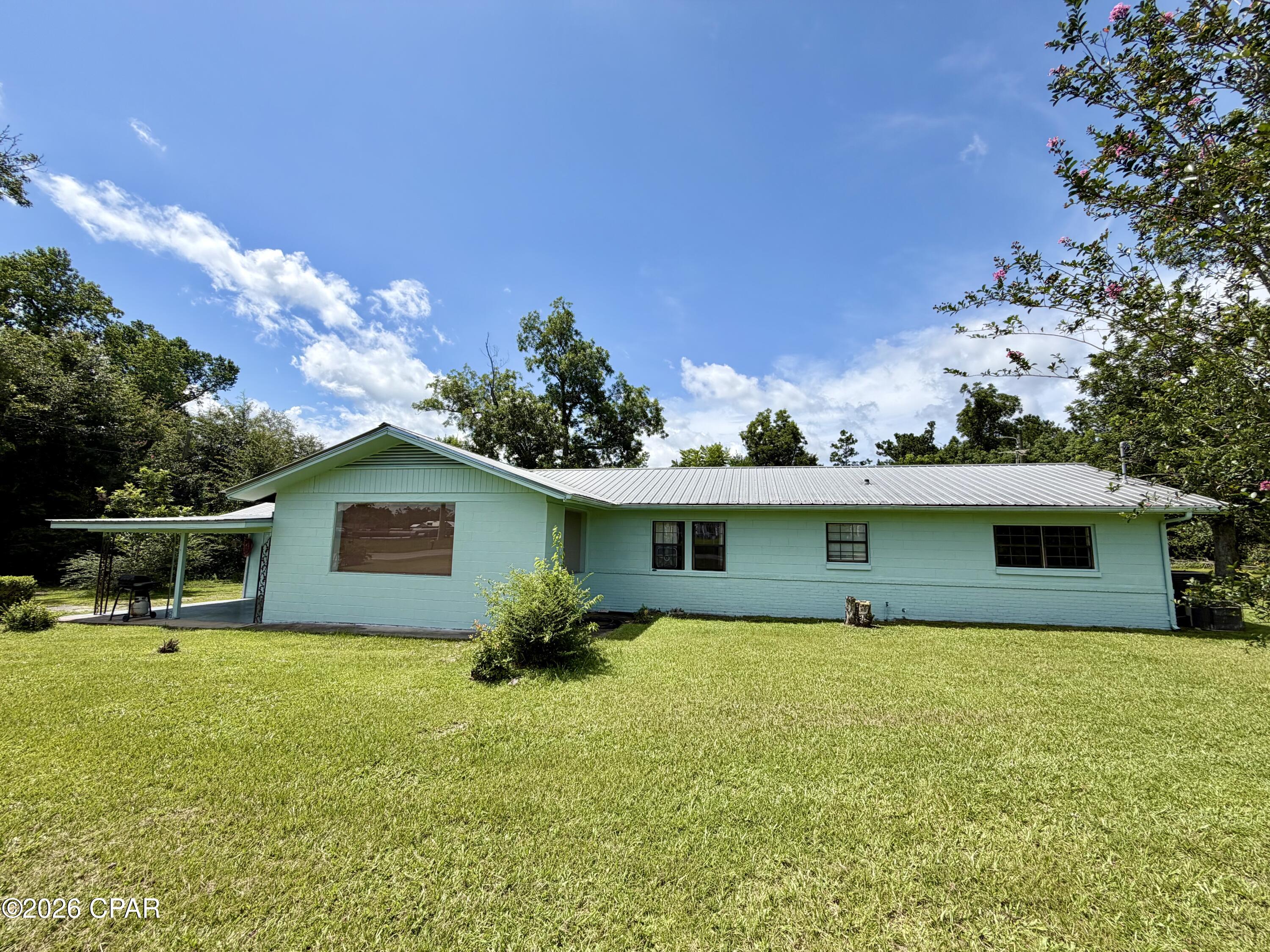 Come bring this spacious 5 bedroom, 2.5 bath concrete block home with a metal roof back to life!  Situated on 7.93 beautiful acres just outside of Marianna, this property offers endless potential for the buyer willing to put in some work and make it their own.
The home features a large floor plan that's perfect for a growing family, along with a kitchen that has already been updated with new cabinets and countertops.  A brand new well has also been installed.  While some improvements have been completed, the home still needs additional updates and repairs, including flooring, interior & exterior paint, light fixtures, and bathroom renovations.  Please note that the bathroom in the master bedroom is currently non-functional due to damage to the septic tank that previously served it.  The seller recommends installing a new septic system for the home.
Adding to the property's value is a 2 bedroom, 1 bath single-wide mobile home offering approximately 644 square feet of living space. The mobile home features a newer roof, sits on a concrete slab, and currently provides rental income.
The land is beautiful, featuring at least five mature pecan trees and plenty of room to enjoy country living while still being conveniently located near Marianna. There is a power line easement across one corner of the property.  A current survey is available.
If you've been dreaming of owning acreage, having room for a large family, and generating additional income from a rental property, this could be the opportunity you've been waiting for.  Contact your favorite Realtor to see this property!