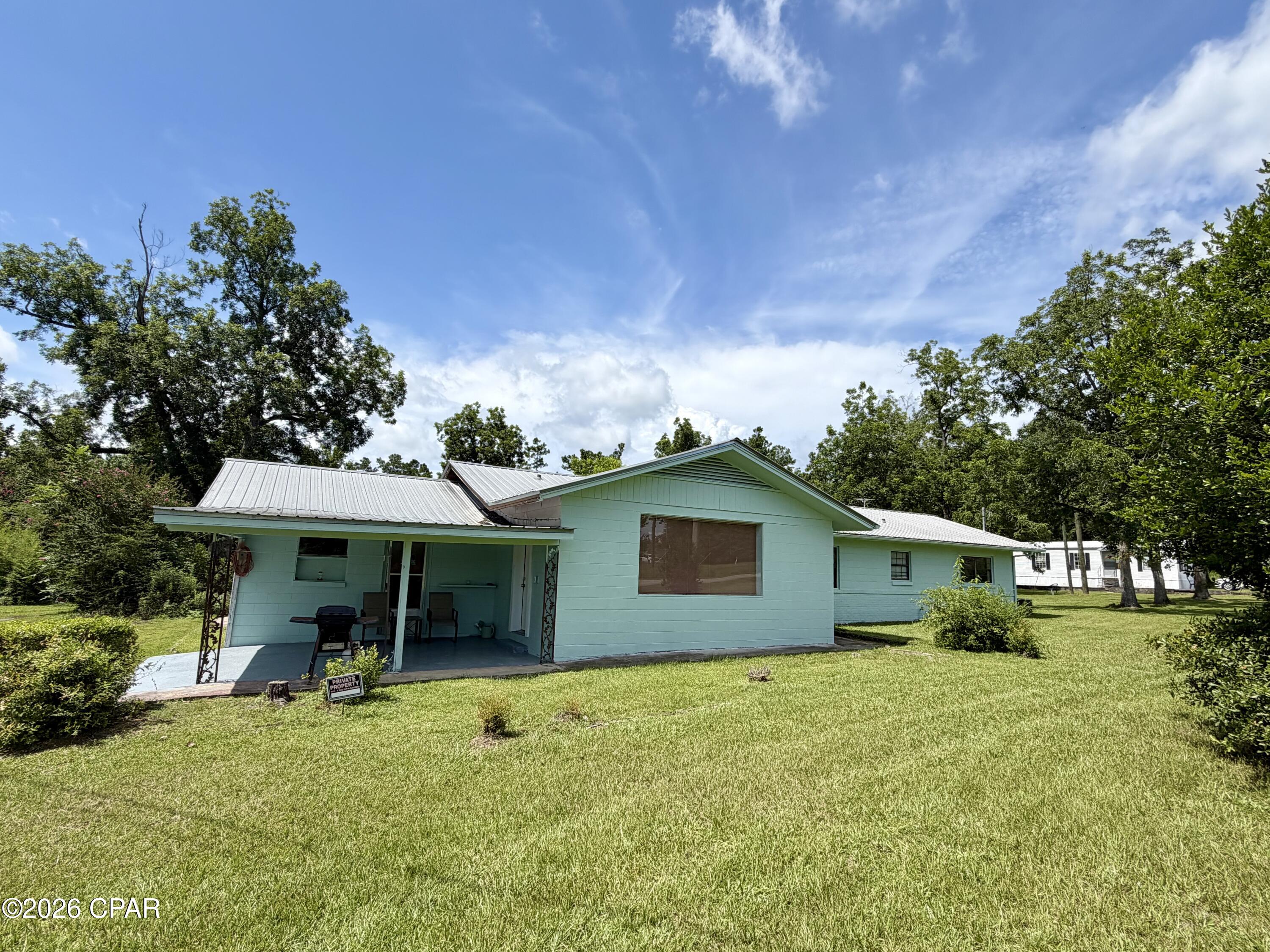 Come bring this spacious 5 bedroom, 2.5 bath concrete block home with a metal roof back to life!  Situated on 7.93 beautiful acres just outside of Marianna, this property offers endless potential for the buyer willing to put in some work and make it their own.
The home features a large floor plan that's perfect for a growing family, along with a kitchen that has already been updated with new cabinets and countertops.  A brand new well has also been installed.  While some improvements have been completed, the home still needs additional updates and repairs, including flooring, interior & exterior paint, light fixtures, and bathroom renovations.  Please note that the bathroom in the master bedroom is currently non-functional due to damage to the septic tank that previously served it.  The seller recommends installing a new septic system for the home.
Adding to the property's value is a 2 bedroom, 1 bath single-wide mobile home offering approximately 644 square feet of living space. The mobile home features a newer roof, sits on a concrete slab, and currently provides rental income.
The land is beautiful, featuring at least five mature pecan trees and plenty of room to enjoy country living while still being conveniently located near Marianna. There is a power line easement across one corner of the property.  A current survey is available.
If you've been dreaming of owning acreage, having room for a large family, and generating additional income from a rental property, this could be the opportunity you've been waiting for.  Contact your favorite Realtor to see this property!