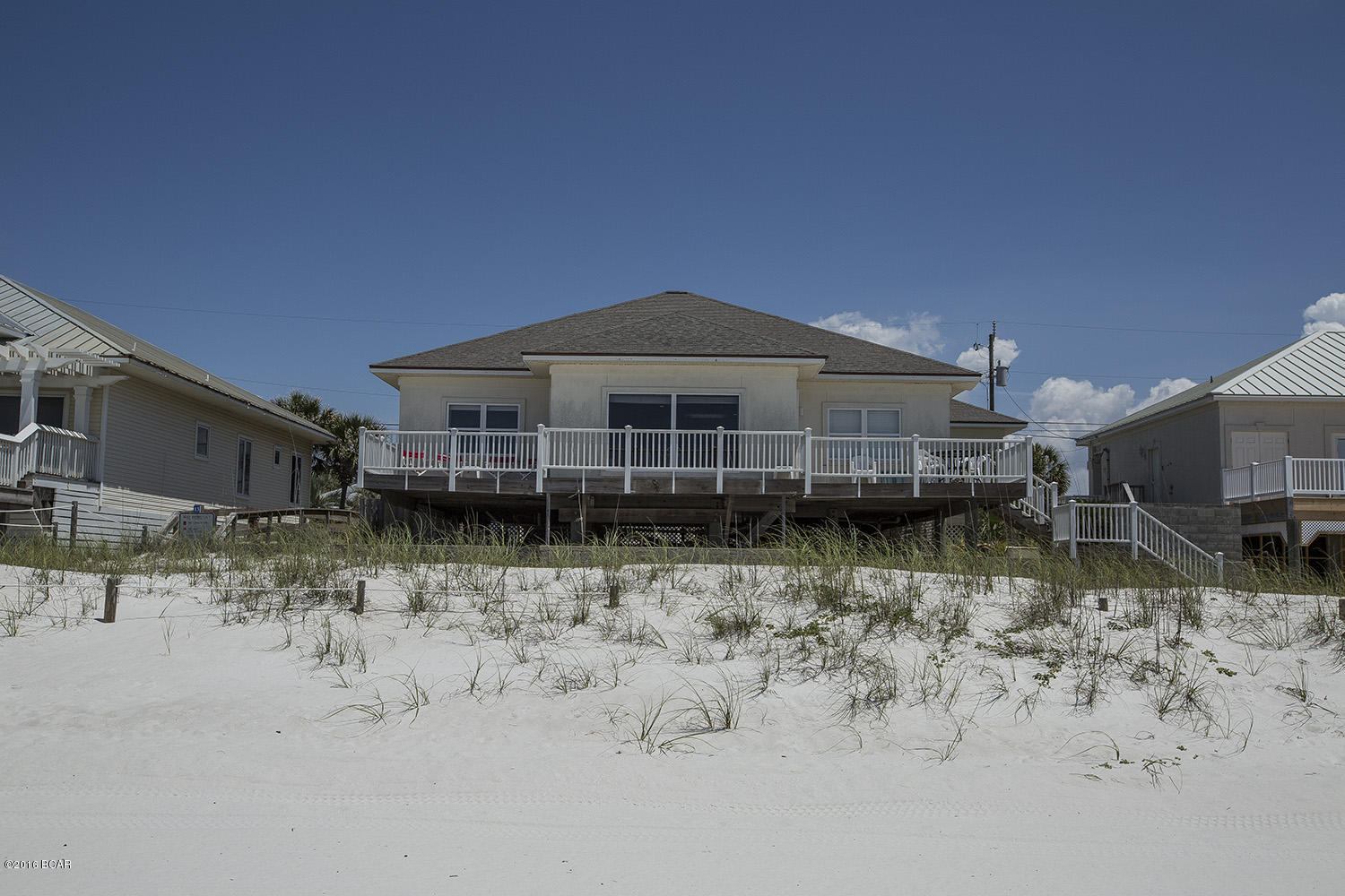 Beautiful Gulf Front Home in quiet area off of Thomas Dr. Quality construction built in 1997 to new building codes after Hurricane Opal. Open great room floor plan with Living and two Gulf front  bedrooms facing the Gulf thanks to the 75' wide lot. Large carport provides plenty of covered parking. Recently redecorated and in established vacation rental program.  Existing reservations will need to be honored by buyer.