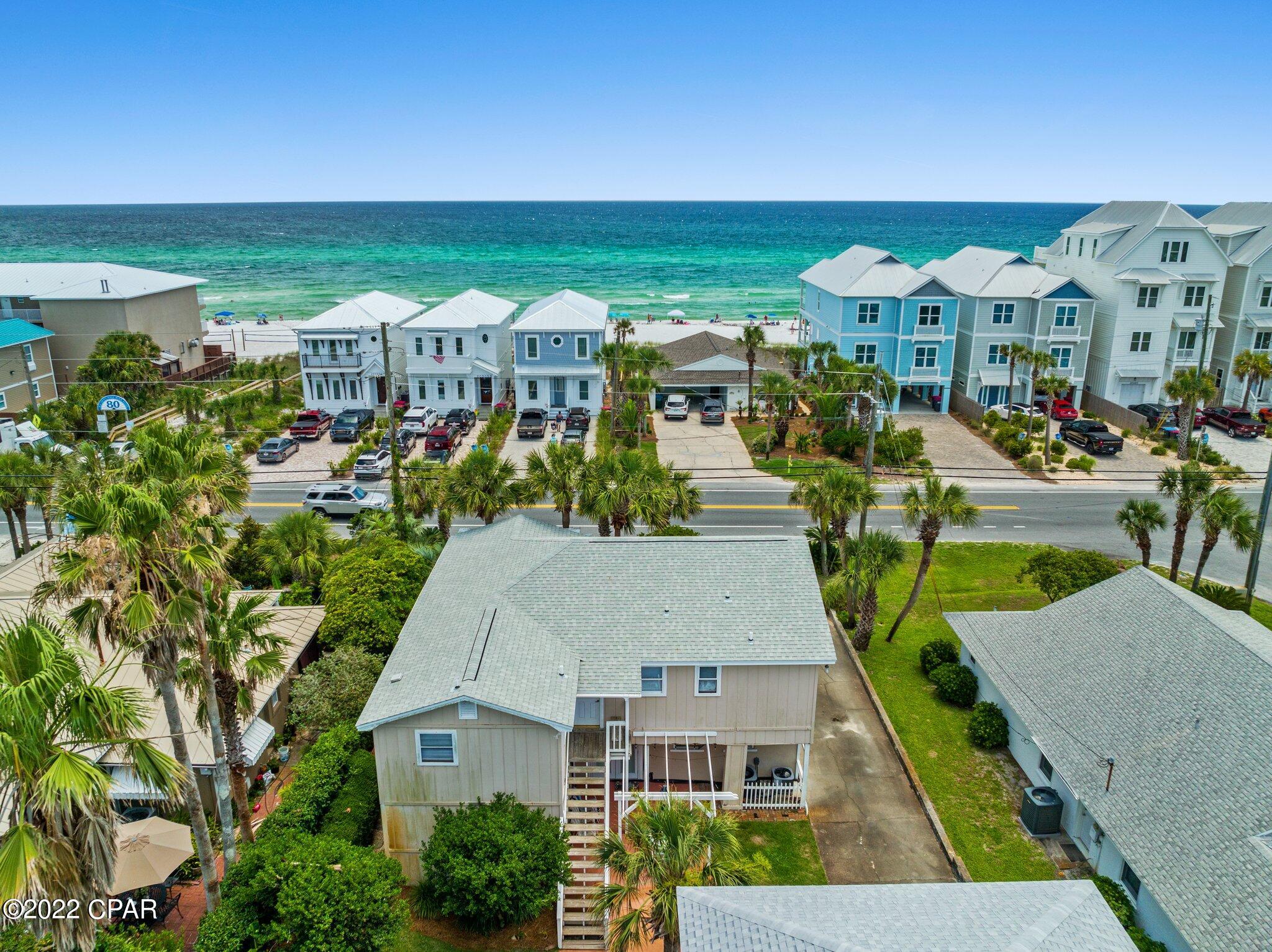 CURRENTLY UNDER CONTRACT, SELLER WILL CONSIDER BACKUP OFFERS. Investor alert! 5/4 beach home directly across from 2 beach access points in the desirable Laguna Beach area. This home is located equal distance (5 miles) between Hwy 30A and Pier Park. Prime vacation rental location!
 
The main home has 2 bedrooms, 2 full baths, a full kitchen and laundry room upstairs. Also a large balcony with gulf views while you're grilling. Downstairs, 2 more bedrooms, 1 full bathroom, another full kitchen, tongue-and-groove ceilings, walk right out the front door across the street to the sandy white beaches.

The driveway leads to the back of the house to the 2 car garage with a 1 bedroom, 1 bathroom carriage house with a full kitchen and peek-a-boo views of the gulf. Beautiful mature landscaped yard. Room for a pool.

Recent major upgrades that have been complete: New Roof 2020 and New HVAC 2020. 4 point inspection report on both structures are in the attached documents.