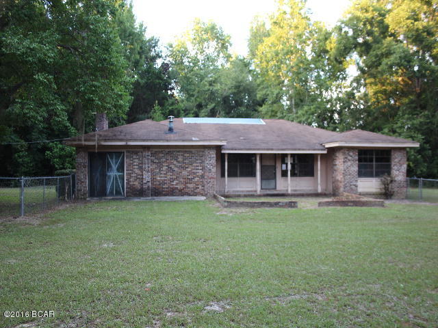 PRICE REDUCTION!! This large brick home is just waiting for loving hands to bring it back to it's potential. You have 3 bedrooms, 2 baths, a large den with fireplace insert and a nice covered back porch/lanai just right for entertaiing plus a deck across the back. The 2 car garage was enclosed to make the master bedroom but this room could be utilized for other purposes if desired. The location is in the country on a large lot.