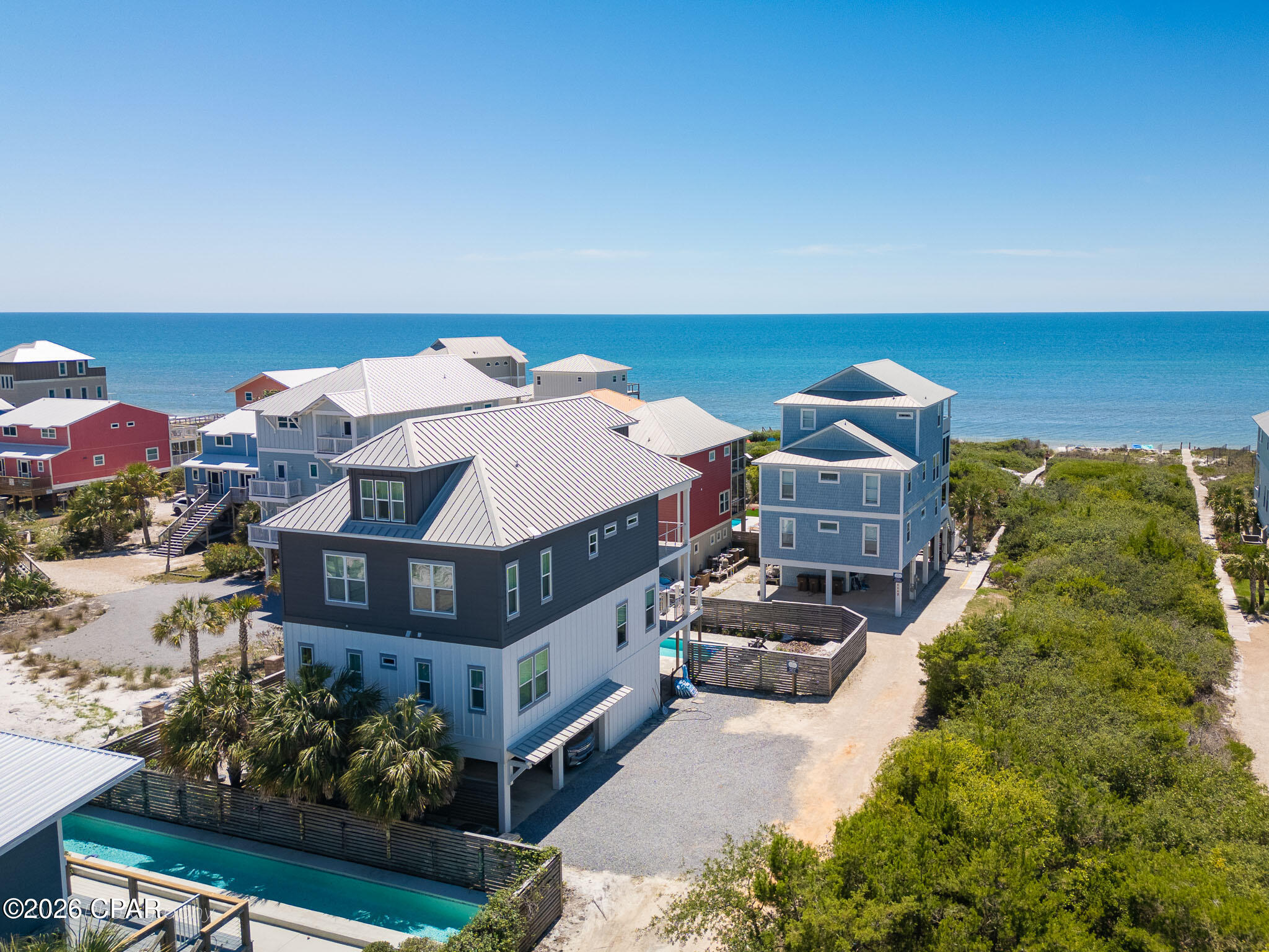 First tier X FLOOD ZONE North Cape San Blas with sub-minute beach access -- no highway crossing, just a short walk over the dunes to some of the whitest sand in Florida. Ownership here means daily access to the Gulf out front and St. Joseph Bay just minutes away, where scalloping in summer, kayaking the flats, and redfish on the fly are part of the rhythm of life. T.H. Stone Memorial St. Joseph Peninsula State Park sits at the tip of the Cape, offering nine miles of protected shoreline, hiking and paddling trails, and some of the most celebrated sunsets on the Gulf Coast. This almost 3,500 sqft. gulf-view home offers 6 bedrooms, 5 baths, and comfortable sleeping for 18, making it equally suited to multi-generational ownership and strong vacation rental income for buyers seeking an investment property. The main level centers on a soaring gathering room with Gulf views, a dining area, and a gourmet kitchen featuring granite counters, stainless appliances, a walk-in pantry, and a center island seating five. The third-floor primary suite opens to a private Gulf-view deck and includes double vanities, a soaking tub, and a separate shower, with two additional bedrooms and the main laundry on the same level. A dedicated top-floor kids' retreat with three twin bunk sets, a sofa, TV, and full bath gives younger guests a space of their own. A residential elevator services the first three floors. Outside, a private 30 x 10.5 heatable pool anchors a spacious deck with sun and shade, served by a poolside kitchenette with drink fridge and ice maker. Additional features include a gas grill, fish cleaning station, enclosed outdoor shower, electronic-lock entry, and parking for five. The 8-mile Loggerhead Walk/Bike Path is at the doorstep. Bed count: 3 Kings, 1 Queen, 1 Full/Full Bunk, 3 Twin/Twin Bunks. Established rental history available on request.