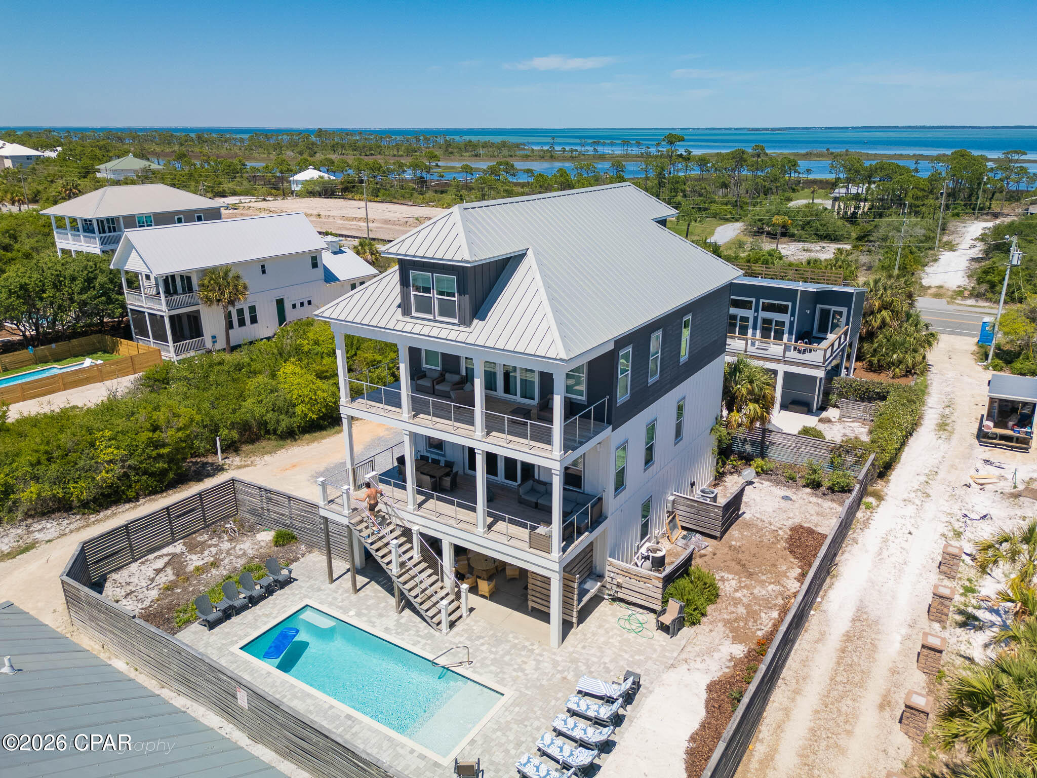 First tier X FLOOD ZONE North Cape San Blas with sub-minute beach access -- no highway crossing, just a short walk over the dunes to some of the whitest sand in Florida. Ownership here means daily access to the Gulf out front and St. Joseph Bay just minutes away, where scalloping in summer, kayaking the flats, and redfish on the fly are part of the rhythm of life. T.H. Stone Memorial St. Joseph Peninsula State Park sits at the tip of the Cape, offering nine miles of protected shoreline, hiking and paddling trails, and some of the most celebrated sunsets on the Gulf Coast. This almost 3,500 sqft. gulf-view home offers 6 bedrooms, 5 baths, and comfortable sleeping for 18, making it equally suited to multi-generational ownership and strong vacation rental income for buyers seeking an investment property. The main level centers on a soaring gathering room with Gulf views, a dining area, and a gourmet kitchen featuring granite counters, stainless appliances, a walk-in pantry, and a center island seating five. The third-floor primary suite opens to a private Gulf-view deck and includes double vanities, a soaking tub, and a separate shower, with two additional bedrooms and the main laundry on the same level. A dedicated top-floor kids' retreat with three twin bunk sets, a sofa, TV, and full bath gives younger guests a space of their own. A residential elevator services the first three floors. Outside, a private 30 x 10.5 heatable pool anchors a spacious deck with sun and shade, served by a poolside kitchenette with drink fridge and ice maker. Additional features include a gas grill, fish cleaning station, enclosed outdoor shower, electronic-lock entry, and parking for five. The 8-mile Loggerhead Walk/Bike Path is at the doorstep. Bed count: 3 Kings, 1 Queen, 1 Full/Full Bunk, 3 Twin/Twin Bunks. Established rental history available on request.