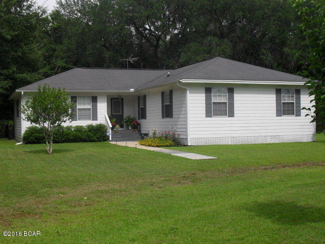 Beautiful well-maintained home on 1 acre on paved state road with 225' frontage. Split floor plan with bonus room adjacent to master suite, suitable for office, nursery, exercise, etc. Ceiling fans in L/R, bonus room, and all 4 bedrooms, three of which have large walk-in closets. Two-inch white faux wood blinds remain on all windows. Large eat-in kitchen with new Bosch stainless steel D/W, Stove & side-by-side refrigerator which remain with home. Nice screened porch off kitchen opens to a deck and covered double carport. Beautiful oak laminate floors throughout, except stone color in kitchen, baths, and large inside laundry room. Total electric, central H/A, private well, septic. Security system installed. 12'X20' metal storage bldg with additions built on. Quiet country living only 15 minutes to historic Marianna, home of Chipola College, Florida Caverns, and Blue Springs Recreation. Also convenient to numerous metro areas such as Panama City Beach, Tallahassee, Dothan, Alabama, etc. Great fishing and boating locations nearby, including famous Lake Seminole.