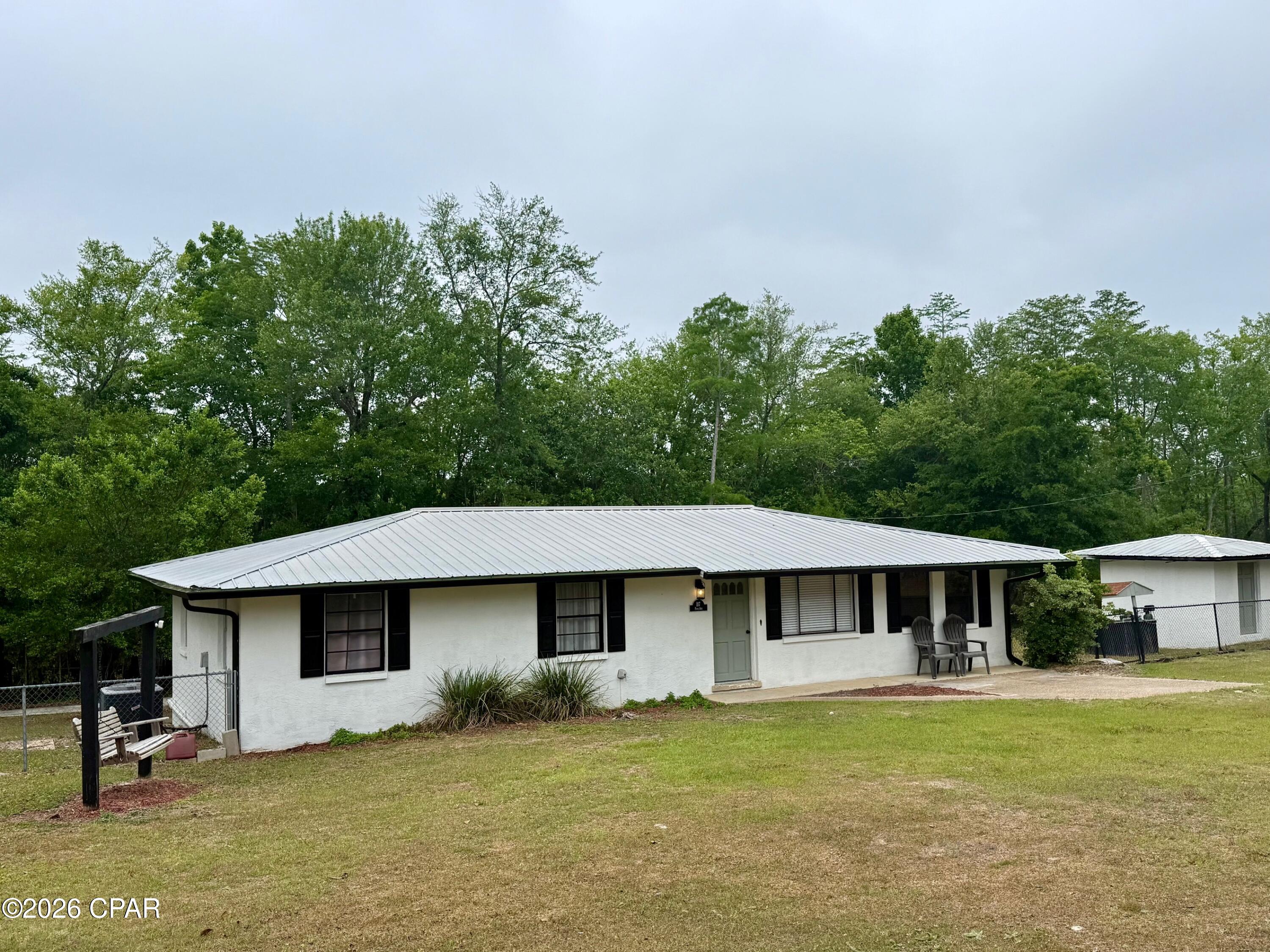 This updated 3 bedroom 2 bath home sits on 1+ acres on the edge of The Dead Lakes waterway. This home has a fenced back yard, metal roof, new LVP flooring and updated appliances, including a new dishwasher and brand new electric range that has never been used. The breakfast bar has track lighting & the new CorTec flooring was just installed by Carpet Country. Each of the bedrooms are of ample size with the master offering a full bath including step in shower. The guest bath has been completely remodeled. Additional features include pecky cypress walls in 2nd living area, updated lighting, freshly painted, back deck and storage building. Home is located just a few miles to downtown Wewa and only 30 minutes to Port St Joe, Mexico Beach, Panama City & Blountstown. No HOA or HOA fees. Don't miss this opportunity to purchase an affordable home in good shape in a great location and fish the Dead Lakes from your back yard! This property has been virtually staged. No furniture or furnishings are included in the sale.