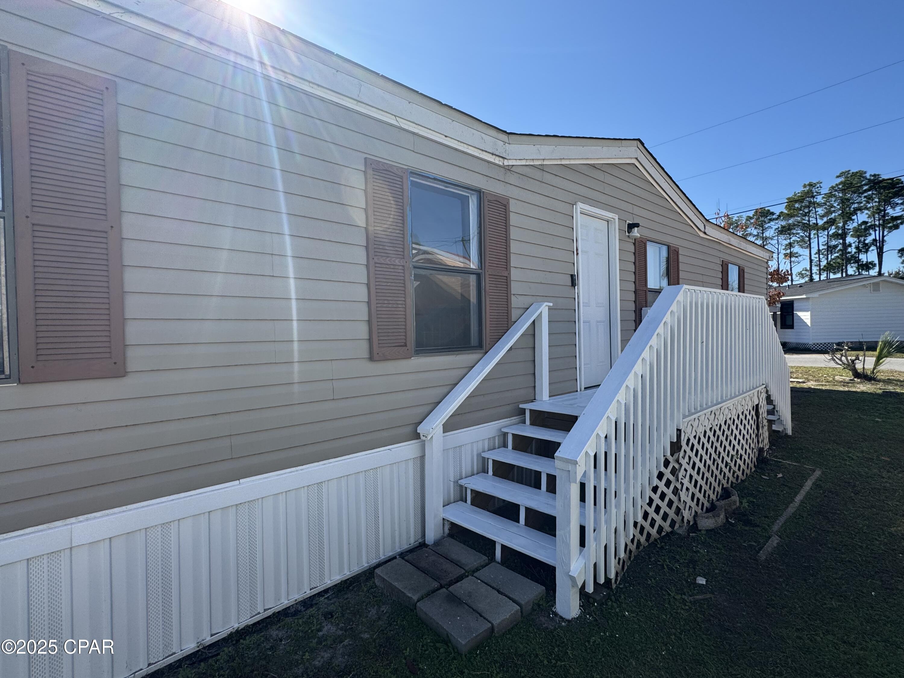 ** Seller Motivated** Welcome to this spacious 3-bedroom, 2-bathroom double-wide home set on a desirable double lot in Bayside Park, just steps from a full service marina that offers  launch services, plus RV and boat storage. Walk into an open living and dining room layout filled with natural light. The updated kitchen features brand-new cabinets, refrigerator, and dishwasher, along with wood look tile flooring and an island that overlooks the living room and sitting area--perfect for everyday living and entertaining.

The split floorplan offers great privacy. The primary bedroom includes double windows, a walk-in closet, and an en-suite bathroom with a new vanity and a relaxing jacuzzi tub/shower combo. On the opposite side of the home, you'll find two additional bedrooms with walk-in closets and a full bathroom with a tub/shower combo and a new vanity.

Recent upgrades include brand-new central AC, a new water heater, new skirting, and LVP flooring throughout the main living areas.

Just past the kitchen is a dedicated laundry room, and out the back door you'll enjoy an enclosed Florida room with windows and a glass door that faces the marina--an ideal spot to relax and take in the coastal breeze.

This home is move-in ready and simply waiting for the new owner to add the finishing touches. Located in Bayside Park, you'll be minutes from Bay County Skate Park, Publix Sports Park, Duplin Winery, Gulf Coast State College, Pirates Voyage Show and all the shopping and dining along Front Beach Road.

Fireplace conveys ''as-is''. Functionality and condition are unknown. This home will make for a make for a great primary home, but could be utilized as wonderful vacation getaway or short & long-term rental investment property.

All measurements and lot dimensions are estimates only-Buyer or Buyer's Agent to verify if deemed important.