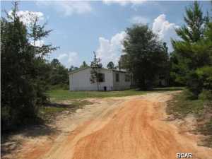 Approximately 16 Acres in the Rural area of SouthEastern Washington County in the Panhandle area of North Florida. Only about 15 minutes South of Interstate 10 and 45 minutes North of Panama City. This exceptional buy is a Foreclosure which is now owned by the Lender, and Lender may provide Financing to Buyer depending upon review of Credit Application. Plenty of land available here for Horses, Farming, or Hunting. The 1998 Homes of Merit 28' x 60' Mobile Home is in need of repair, but the shell and interior walls are in place with 4 Bedrooms, 2 Baths, Fireplace in Family Room, separate Laundry Room, etc. Electric Service, Well, and Septic, are in place; however, Seller has no knowledge of the condition of these systems and makes no warranty regarding these systems or any improvements