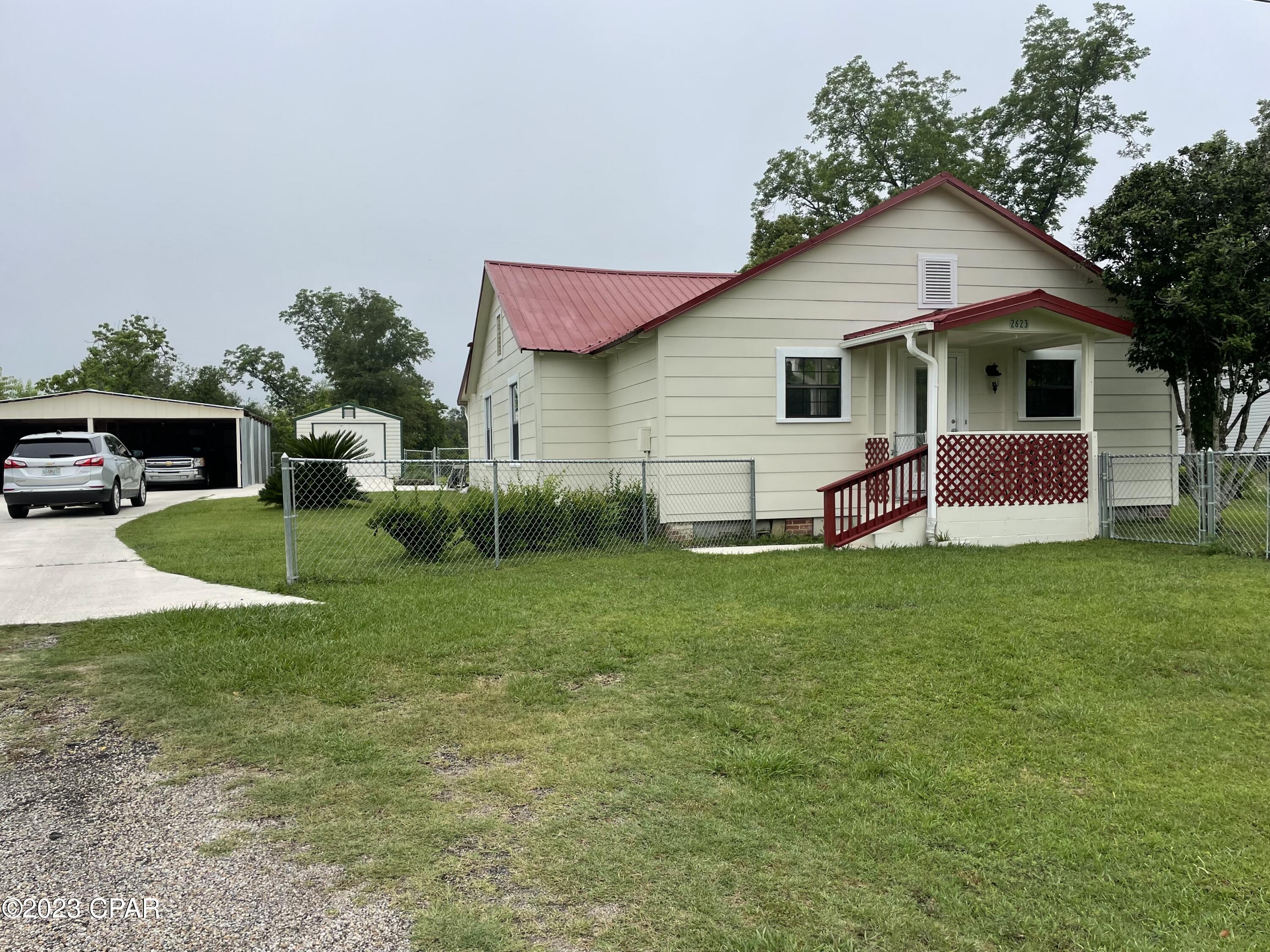 This cozy 2/2 cottage home has had some recent updates!  New flooring, new gas stove and refrigerator, new bathroom added, freshly painted exterior, new workshop addition, and new chained link fence around the entire property.  The screened in back porch is a great place to entertain and the beautiful back yard has many fruit trees planted, grape vine, etc.  There is a two car open garage with a small addition at the rear, along with a large storage building.  You will be close to town and hospital.  Make an appointment today!