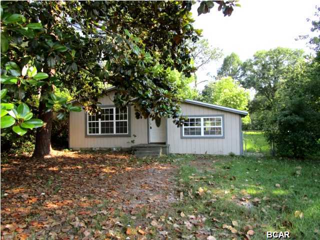 Attractive home in Lynn Haven on a large fenced lot! This home features a hardwood floors throughout the living area and all three bedrooms. The kitchen is spacious and has an eat-in dining area. From the kitchen, there is both a utility room for the washer and dryer, and there is an additional storage room attached. The backyard is fenced with a yard building. Home is being sold in its AS IS condition.
