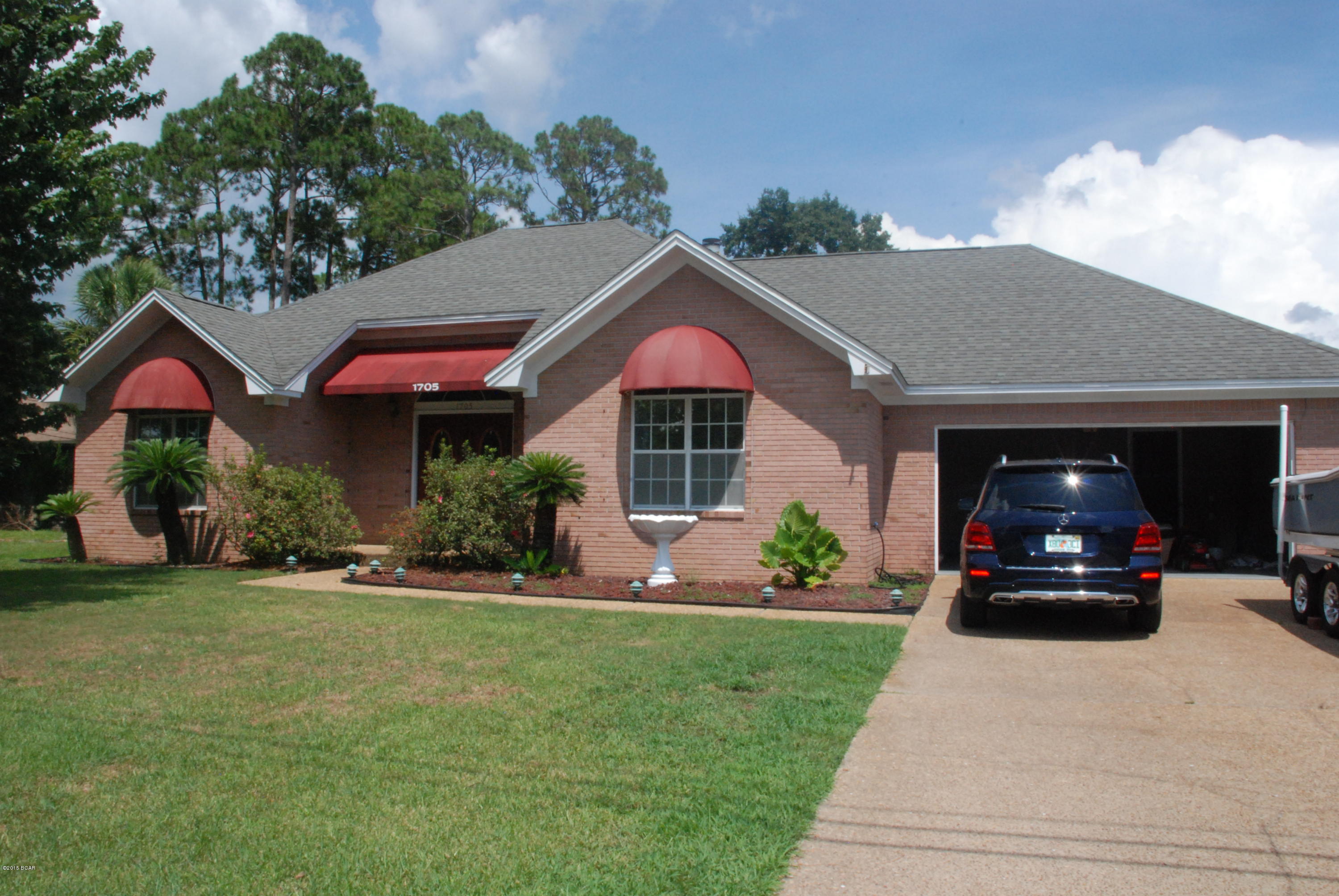 Spacious brick home with in-ground, enclosed pool in desirable Lynn Haven. This three bedroom, two bath home has much to offer. The family room has a vaulted ceiling, hardwood floors, a fireplace and a pass-thru to the kitchen. The home offers a formal dining room in addition to an eat-in kitchen. The master room is very large and has a door to the enclosed pool patio. The master bath has separate shower, Jacuzzi tub, separate double vanities and a walk-in closet. The enclosed pool has a large covered patio, separate hot tub and still plenty of yard remaining outside the screened enclosure. There is also a large workshop and the back yard is privacy fenced.