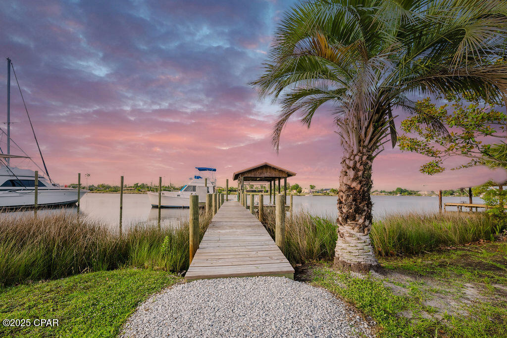 Welcome to 6905 Hugh Drive, where modern luxury meets relaxed coastal living. Completely remodeled from the studs up in 2023, this stunning 3-bedroom, 2-bathroom waterfront home sits on nearly 0.6 acres with 100 feet of deep saltwater frontage on Callaway Bayou, offering direct access to East Bay, Shell Island, and the Gulf beyond. Whether you're an avid boater or simply looking for peaceful waterfront living, this property delivers the ultimate Florida lifestyle.

Inside, you'll find a light-filled open floor plan with soaring 15-foot vaulted ceilings and luxury vinyl plank flooring throughout. The showstopping chef's kitchen features quartz countertops, stainless steel appliances, white shaker cabinetry, and an oversized center island, seamlessly flowing into the spacious living and dining areas--perfect for entertaining.

This home was rebuilt with quality and peace of mind in mind and features all new systems in 2023, including HVAC, hot water heater, electrical wiring, sheetrock, and more. The exterior is equally impressive with a beautiful metal copper roof that adds both durability and timeless character.

Step outside through French doors from the living room to a large covered back porch overlooking the bayou, ideal for relaxing or entertaining while enjoying breathtaking sunsets. The primary suite also features private French doors leading to its own deck, providing the perfect spot for morning coffee and serene waterfront views.

For boating enthusiasts, the new private dock includes power (50 amp and 110 amp), water, and a boat lift. The property also includes a new privacy fence with a double gate and additional parking with 11' clearance for RV or boat storage.

Offering peace, privacy, and endless waterfront adventure, this move-in-ready bayou-front home is just minutes from town while feeling like a private retreat.

Schedule your private showing today and experience the beauty of 6905 Hugh Drive for yourself.

All measurements are approximate. Information is believed to be accurate but should be verified by buyers if important.