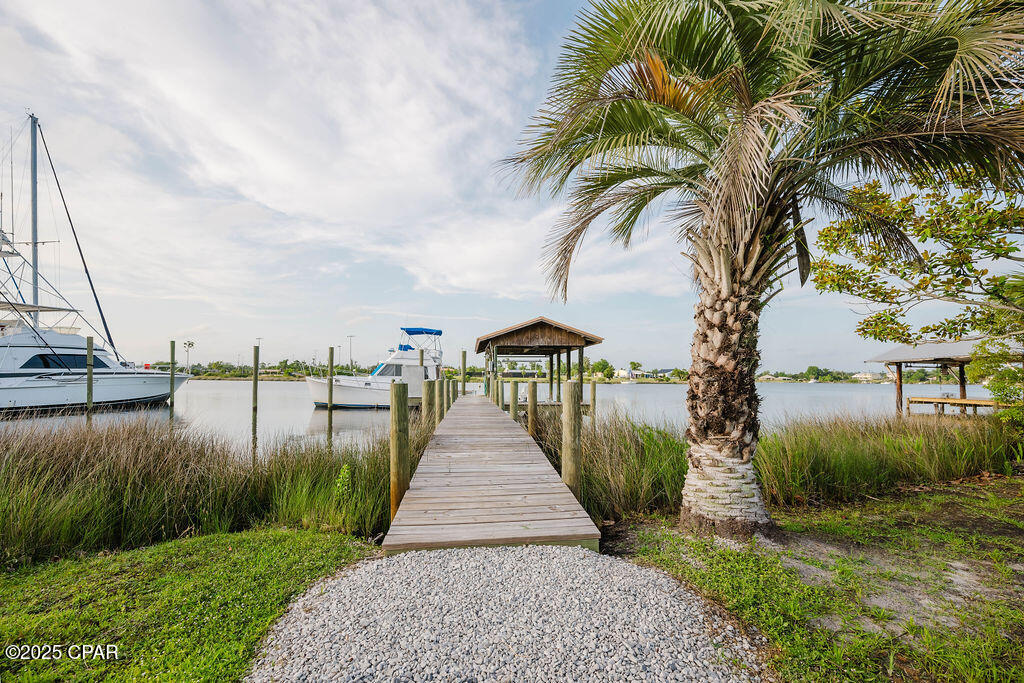 Welcome to 6905 Hugh Drive, where modern luxury meets relaxed coastal living. Completely remodeled from the studs up in 2023, this stunning 3-bedroom, 2-bathroom waterfront home sits on nearly 0.6 acres with 100 feet of deep saltwater frontage on Callaway Bayou, offering direct access to East Bay, Shell Island, and the Gulf beyond. Whether you're an avid boater or simply looking for peaceful waterfront living, this property delivers the ultimate Florida lifestyle.

Inside, you'll find a light-filled open floor plan with soaring 15-foot vaulted ceilings and luxury vinyl plank flooring throughout. The showstopping chef's kitchen features quartz countertops, stainless steel appliances, white shaker cabinetry, and an oversized center island, seamlessly flowing into the spacious living and dining areas--perfect for entertaining.

This home was rebuilt with quality and peace of mind in mind and features all new systems in 2023, including HVAC, hot water heater, electrical wiring, sheetrock, and more. The exterior is equally impressive with a beautiful metal copper roof that adds both durability and timeless character.

Step outside through French doors from the living room to a large covered back porch overlooking the bayou, ideal for relaxing or entertaining while enjoying breathtaking sunsets. The primary suite also features private French doors leading to its own deck, providing the perfect spot for morning coffee and serene waterfront views.

For boating enthusiasts, the new private dock includes power (50 amp and 110 amp), water, and a boat lift. The property also includes a new privacy fence with a double gate and additional parking with 11' clearance for RV or boat storage.

Offering peace, privacy, and endless waterfront adventure, this move-in-ready bayou-front home is just minutes from town while feeling like a private retreat.

Schedule your private showing today and experience the beauty of 6905 Hugh Drive for yourself.

All measurements are approximate. Information is believed to be accurate but should be verified by buyers if important.