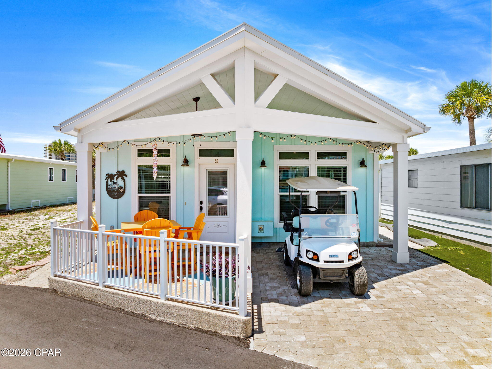 Welcome to coastal living at its finest in the highly desirable gated golf-cart community of Venture Out in Panama City Beach! Built in 2020, this beautifully designed 3-bedroom, 2-bath beach home offers the perfect blend of modern coastal charm and low-maintenance living just steps from the sugar-white sands of the Gulf of Mexico.

From the moment you arrive, you'll love the inviting curb appeal featuring a spacious covered front porch, paver driveway, and bright beachy exterior colors. Inside, the open-concept floor plan showcases soaring vaulted ceilings with exposed wood beams, luxury vinyl plank flooring, quartz countertops, custom cabinetry, stainless steel appliances, and an oversized kitchen island perfect for entertaining family and guests.

The spacious living and dining areas flow seamlessly together, creating a light and airy atmosphere throughout the home. The beautifully appointed kitchen offers ample cabinet space, stylish coastal finishes, and modern fixtures that make this home feel both elegant and relaxed.

Outside, enjoy multiple outdoor seating areas, extra paver space, and convenient overflow parking located behind the home -- a rare and valuable feature within the community. The covered parking area is perfect for your golf cart and beach gear, making trips to the beach and resort amenities effortless. Rental history for 2025 is available and the house has bookings on the books for 2026!

Located inside Venture Out, one of Panama City Beach's premier gated golf-cart communities, residents enjoy private beach access to approximately 300 feet of Gulf frontage along with access to two swimming pools, tennis courts, pickleball, basketball courts, shuffleboard, fishing pier, private boat ramp, marina, playground, and 24-hour gated security.

Whether you are looking for a full-time residence, vacation getaway, or income-producing rental property, this newer construction home checks all the boxes for beach living and investment potential.