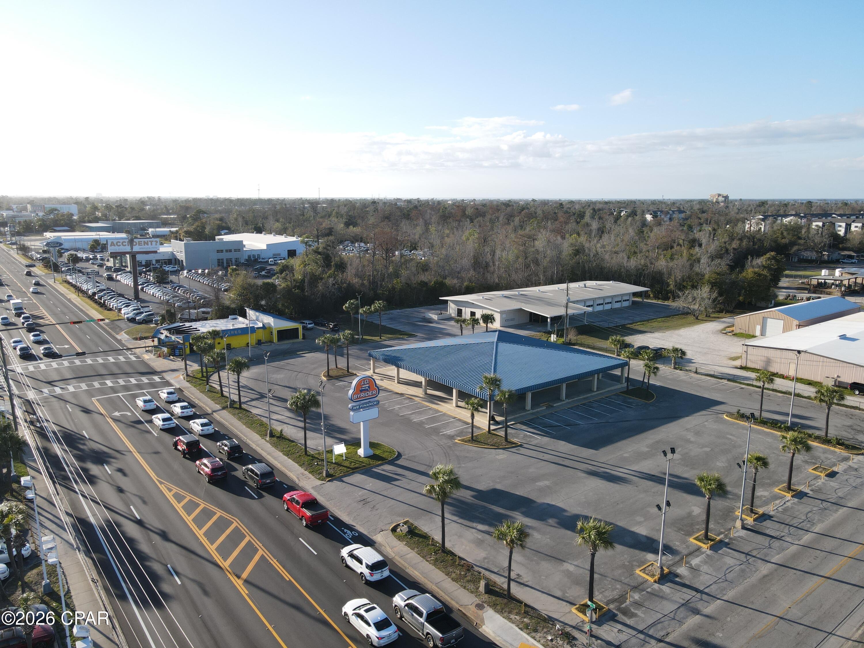 Positioned along one of Panama City's most recognized commercial corridors, 704 W 15th Street represents a rare opportunity to acquire a substantial, fully improved automotive commercial property in the heart of Bay County's established dealership row.
The offering consists of two contiguous parcels totaling approximately 8.09 acres. The improved parcel encompasses 2.53 acres and is developed with a professional office/showroom building and a fully equipped automotive service garage, providing immediate operational capability for a dealership, fleet operator, or service-oriented automotive business. The second parcel comprising 5.56 acres offers significant expansion potential, additional inventory staging, overflow parking, or future development -- a premium commodity in this high-demand corridor.
The property sits at a prominent corner location with access from both Highway 98 (15th Street) and Florida Avenue Showcase, providing exceptional visibility and ingress/egress for high customer traffic volumes. It is centrally located amongst the other new car dealers in the county Showcase, making it an ideal home for a new or used car dealership, watercraft dealer, or any automotive-related enterprise seeking to benefit from co-tenancy with established franchise dealers.
Property Highlights:

Total site: ±8.09 acres across two parcels (2.53 AC improved | 5.56 AC additional)
Improved parcel features office/showroom and automotive garage
Corner location -- dual access from Hwy 98 (15th St) & Florida Avenue
Situated within Panama City's primary automotive retail corridor
Excellent visibility and high traffic counts on a major arterial highway
Suited for auto dealership, powersports, watercraft, fleet, or service operations

This property offers the scale, infrastructure, and strategic location rarely available in Panama City's competitive automotive market. Whether for owner/operator use, investment, or redevelopment, 704 W 15th Street delivers a compelling combination of improved facilities and raw land in one of Bay County's most active commercial destinations.