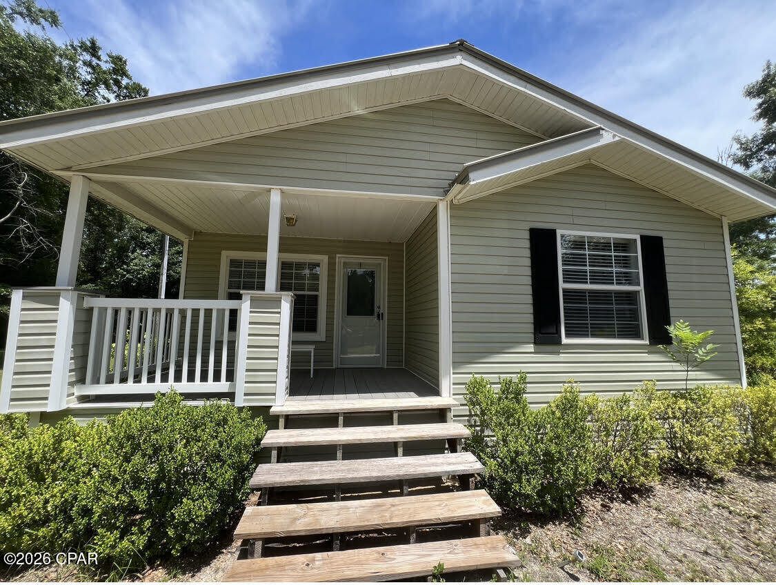 Nice 2007 year doublewide on a permanent foundation, 28'x60' footprint on a 1 acre lot, located off Pittman Hill Road (South of Marianna) which features a spacious covered front porch, a big screened-in back porch which leads out to an open wood deck off the back of the mobile home, nice metal roof, skirting, well and septic, features: 3 bedrooms, 2 baths, Window treatments/blinds remain, Dining room furniture included all kitchen appliances and the washer and dryer are included too. There is a huge pole barn with attached storage shed/ workshop. This home is located South of downtown Marianna, FL. (see directions)