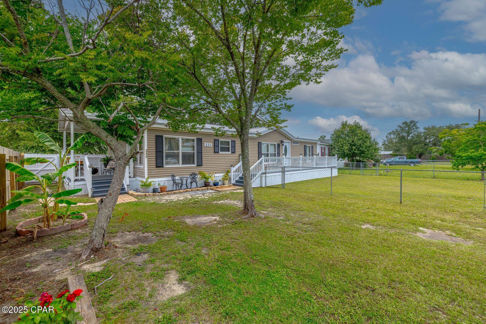 Wow!  Take a look at this fabulous manufactured mobile home which has many upgrades.   New metal roof installed around 2019, new flooring recently installed, new interior painting.  Brand new $8000 air conditioner installed in 2024.   Entering the open floor plan, you are greeted by a large living room and sitting in that room, you feel a warmth and tranquility as this does not feel like your normal mobile home.  Sellers have left no corners untouched and one of the nicest mobile homes in the area. Custom draperies throughout the home, thus giving an added touch to all window elegance.  Beautiful ample kitchen with plenty of cabinetry, stainless steel appliances and informal dining area.  A pantry, washer and drier are incorporated in the kitchen area. Next to the living room, you have a formal dining section.   Bedrooms are large with new flooring and upgraded bathrooms.  Master bedroom has ample room with separate shower and, tub fully remodeled. Home sits in a large lot and fully fenced in.  The back yard has been installed with new privacy fence and a large custom barn sits in the back for your mancave needs like a workshop, storage etc.  Sitting porch in the rear, side and front of the home with new decking.  Enjoy the peaceful quietness in this well maintained and manicured neighborhood.  The property is only two blocks from the Callaway Public boat ramp, walking park.   Shopping and restaurants, and Only 20 minutes from Tyndall A.F.B. Priced to sell quickly. Don't miss out.  Some furnishings could be negotiated but not included in the sale.