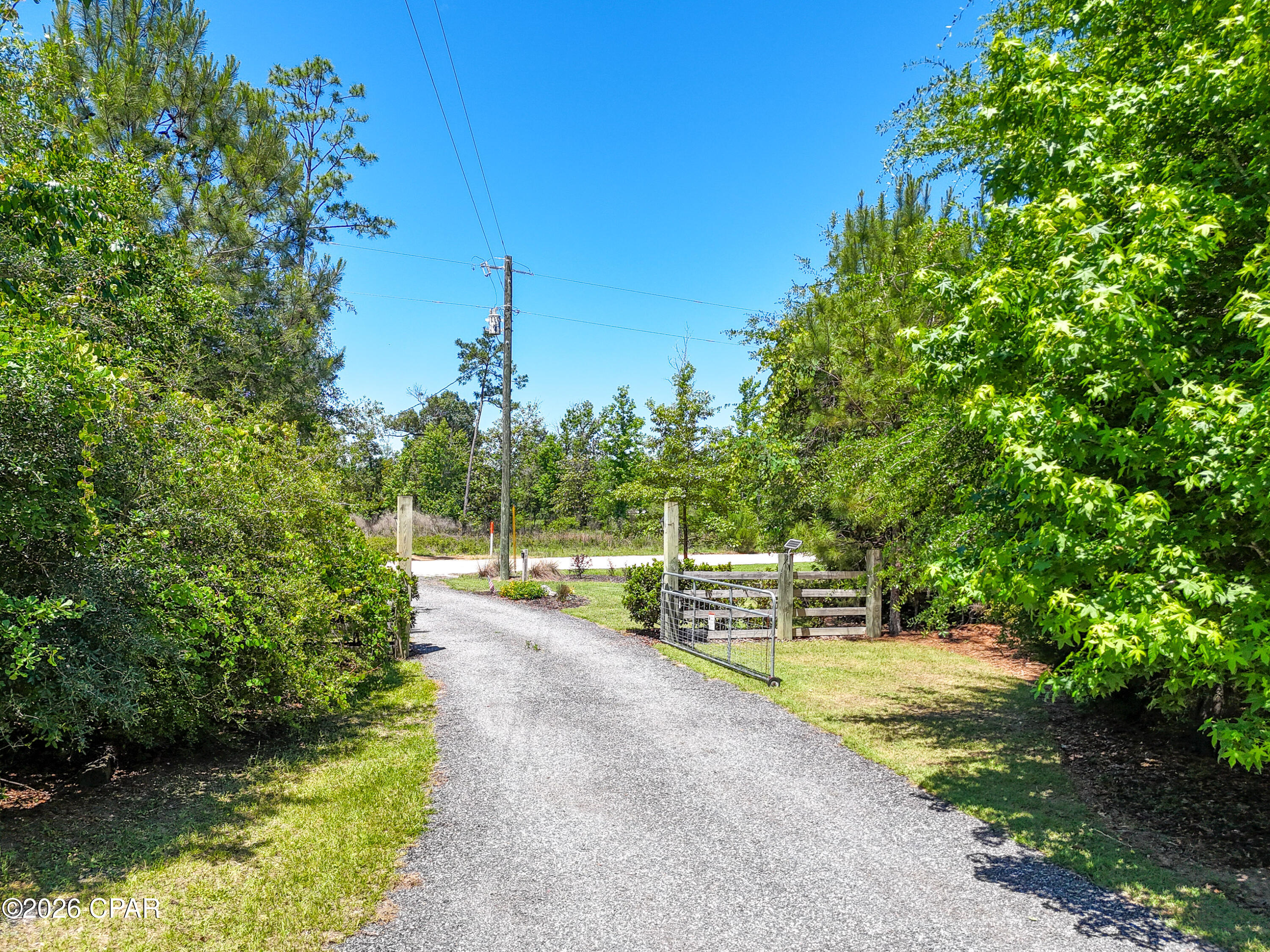 Nestled among the peaceful countryside of Altha, this beautifully prepared 2.96-acre homesite at 17103 NW Chipola Heights Rd offers the perfect blend of privacy, functionality, and natural Northwest Florida beauty. From the moment you arrive through the electrically operated gated entrance, you'll appreciate the care and attention poured into this one-of-a-kind property. A professionally manicured landscape featuring lush sod and personally selected trees creates a park-like setting that feels both welcoming and serene, while frequent visits from local deer add to the tranquil country atmosphere.

A gravel driveway leads to a prepared homesite with a pad already in place for a 62 x 30 mobile home, making this property ideal for those ready to build or place their dream setup with ease. The property is thoughtfully equipped with a septic system, private well, and reverse osmosis water softening system already installed for added convenience and comfort.

Outdoor enthusiasts and hobbyists alike will appreciate the versatile features throughout the property, including a 24 x 24 shop space including a 12x12 storage facility, additional parking space for an RV or boat, and raised garden beds perfect for growing fresh produce right at home. Whether you're seeking a quiet retreat, a weekend getaway, or a future homestead, this property offers the flexibility and infrastructure to make your vision a reality.

Located just minutes from the scenic Chipola River and convenient access to Florida State Road 20, you'll enjoy the perfect balance of rural seclusion and accessibility. The property is approximately 50 miles from the white sand beaches of Panama City Beach and roughly 90 miles from Tallahassee, allowing you to enjoy small-town country living while remaining within reach of shopping, dining, entertainment, and the Gulf Coast lifestyle. Quiet mornings, star-filled nights, and the beauty of Old Florida await at this exceptional Altha property.