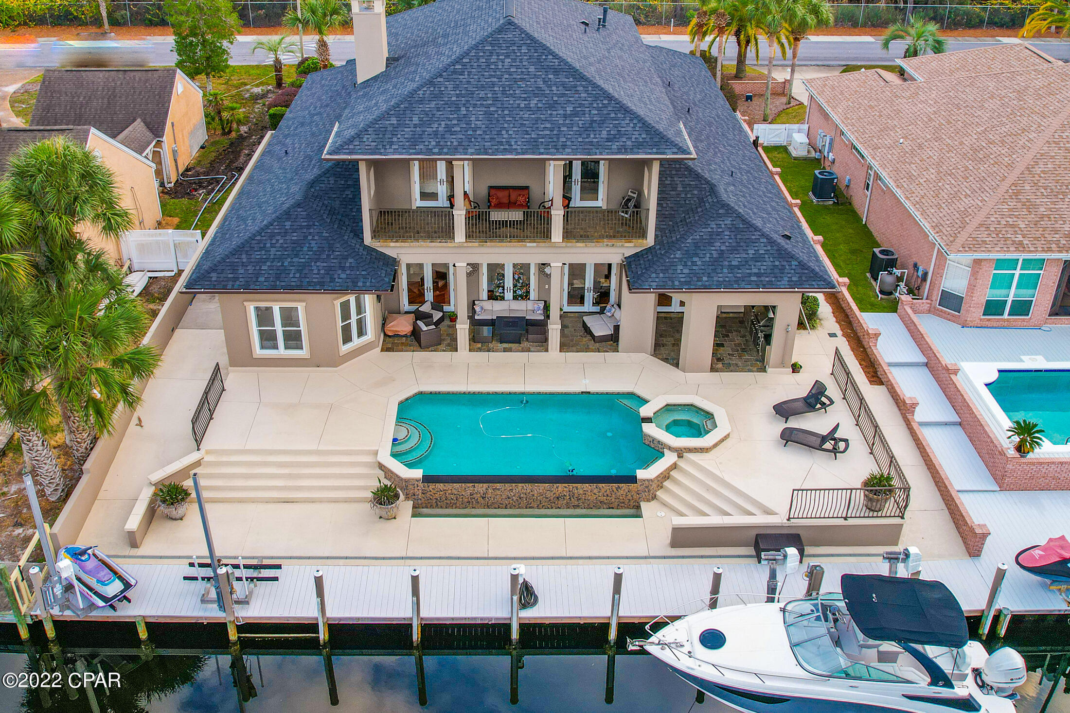 Mesmerizing CANAL FRONT home featuring a Heated Infinity Pool w/Hot Tub, Whole Home Generator, Boat Dock/Lift with 2 Jet Ski Lifts, Seawall, Outdoor Kitchen, and Minutes to the Beautiful Gulf-of-Mexico. From the time you enter the grand foyer you can feel the space this open concept home has. The living room is straight ahead featuring river bottom pinewood floors that are outlined with travertine, gorgeous stone gas fireplace, and triple French doors overlooking the pool and canal. To the immediate right is a bonus room, which could be used as a 4th master suite with beautiful custom windows allowing for natural lighting and features a wet bar with an ice maker. The dining room is to the immediate left with custom arches and a stunning chandelier with matching scones. Where do I start with the gourmet kitchen... This is a chefs dream with granite countertops, upgraded appliances to include a six burner Dacor gas stovetop and oven with a separate steamer, warming drawer, built-in refrigerator to match cabinetry, separate convection oven, wine refrigerator, kitchen island with a vegetable sink, all with a travertine backsplash. The amount of cabinetry in this kitchen is amazing with more than enough space for those holiday dishes! The master bedroom overlooks the canal with stunning morning views and the master bath is a dream. Featuring an oversized travertine shower with steamer, double vanity sinks with granite countertops, extensive cabinetry, makeup desk, jacuzzi tub, with a split entry closet with built-ins, cabinetry, and even a built in safe. The laundry is on the 1st floor and includes plenty of working space to include granite countertops, sink, extensive cabinetry, and the washer and dryer remain with the home. The second floor features a large open bonus room, currently set up as a gym, but could be used as a 2nd living room, office, playroom, or anything your heart desires. The custom windows allow for beautiful natural light and there is even a wet bar with a sink and refrigerator for entertaining. There is a large walk-in storage off the bonus room that is 14.6x5.11, that also includes pull down attic storage. The other two bedrooms face the canal/pool, and both feature French doors leading out to the 28.8x7.7 covered balcony with a beautiful view of the outside entertaining area. There is also a full bath on the second floor with granite countertops and double vanity sinks. This home has so much to offer and attention to detail and elegance defines this home. The custom brick paver circular driveway compliments the stunning grand entrance and lush landscaping surrounds the home. The back of the home is where you will spend most of your time. The backyard is an entertainers dream featuring a 43.10x10 covered porch with an outdoor kitchen, gas grill, sink, and refrigerator, outdoor shower, outdoor bathroom, beautiful infinity pool with edge overflow, hot tub, 10,000lb boatlift with water/electricity, and two jet ski lifts. There is too much to mention on this home with the limited characters we have, so please ask your realtor to print out the key feature sheet from the MLS. Additional Features and upgrades include: New roof, gutters, soffits-2020, 3 AC units with one new in 2022, Pool heater replaced 2020, Polaris and pool pump replaced 2020, new interior and exterior paint, Pool decking/seawall was structurally reinforced in 2020, garage floor recently painted, alarm system, lawn irrigation with a separate meter, upgraded lighting, Navien tankless water heater 2019, 12-ft ceilings on the first floor with 13 inch crown molding, surround sound on the 1st floor, and other than the 2 bedrooms upstairs which are carpet, the home is all river bottom pinewood or travertine flooring. If you are not familiar with Bay Point, it is our premier gated community with 24-hour security. This private waterfront community features a newly built full-serv boats as large as 130 feet, Jack Nicklaus golf course, tennis, spa, restaurants, and even their own post office. If this sounds like the home you have been looking for, contact your realtor for a private showing before your dream of owning a piece of luxury becomes someone else's reality. Age, Sq.Ft., Room dimensions, schools, taxes, are all estimates. It is the buyer's responsibility to verify by a personal or professional inspection if important.