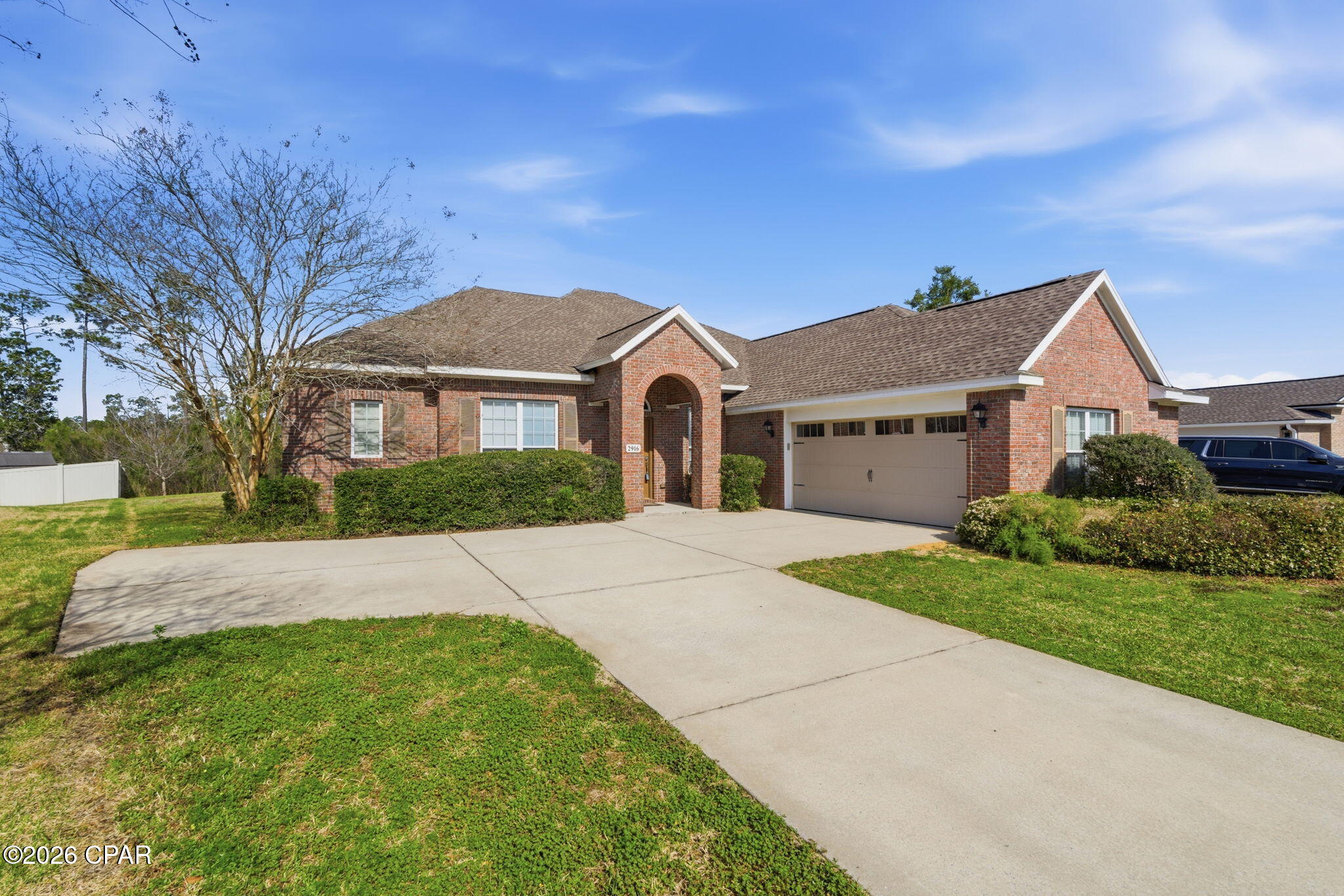 Positioned on a private cul-de-sac lot in the prestigious Hawks Landing community in Panama City, this substantial all-brick 5-bedroom, 4-bathroom executive residence offers 3,605 square feet of thoughtfully designed living space backing to a wooded buffer for added privacy. Built in 2007, the home combines durable construction with generous proportions and architectural detail rarely found in this price range.

Ten-foot ceilings throughout the main level and nine-foot ceilings upstairs enhance the sense of openness and scale. Crown molding, arched openings, and decorative columns add timeless character, while genuine hardwood flooring anchors the primary living areas, complemented by ceramic tile and carpet in designated spaces for comfort.

The main living area offers exceptional gathering space centered around a gas fireplace with built-in shelving and views of the private backyard. The kitchen provides granite countertops, stainless steel appliances, abundant cabinetry, recessed lighting, and a raised breakfast bar that opens seamlessly to the living space, making it well suited for entertaining or larger households.

The oversized primary suite serves as a private retreat with dual granite vanities, a corner jetted tub, and a separate glass-enclosed shower. Four additional bedrooms and multiple full bathrooms provide flexibility for guests, office needs, or multi-generational living. The upstairs bonus room with full bath access adds valuable separation, ideal for a media room or private guest suite.

The covered rear porch extends the living space outdoors and overlooks a backyard with no immediate rear neighbors. The irrigation system operates on reclaimed water, and utilities are serviced through the City of Lynn Haven.

Located within walking distance to Bay Haven Charter Academy and A. Crawford Mosley High School, and convenient to grocery, dining, and retail amenities, this property offers both space and accessibility in one of Panama City's most established neighborhoods.