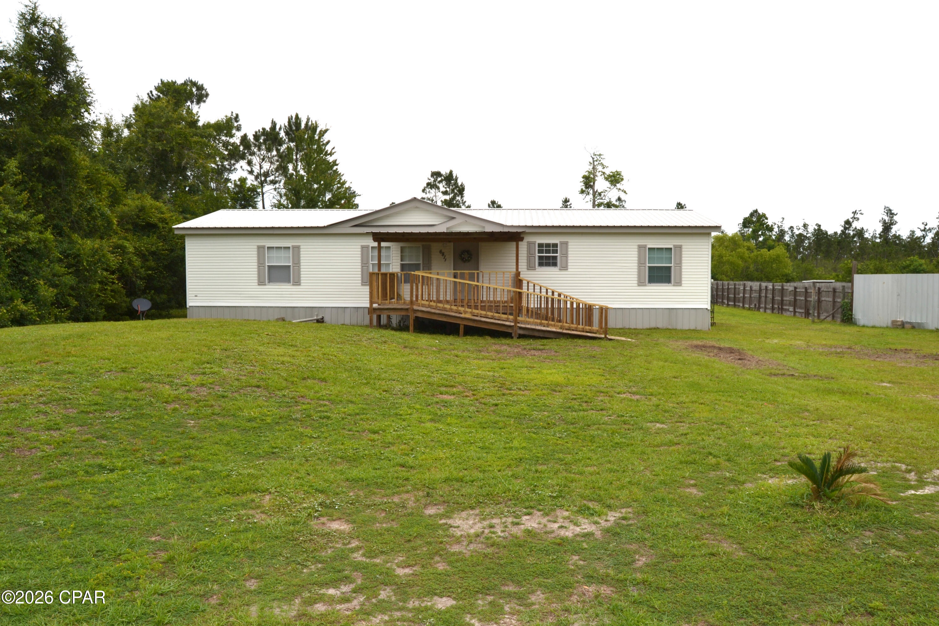 LIKE NEW, freshly renovated 3 bedroom, 2 bath home located in a private rural setting just 20 minutes from Panama City.   This home looks and feels like brand new because it has been completely transformed with new paint, life proof flooring, crown molding, new counter tops, new stainless appliances and and brand new master bath.   If you are looking for space, the interior of the home has a large living area, huge kitchen with island and a formal dining room. The master bedroom has a new shower and sinks and has two walk in closets.  Both bedrooms 2 and 3 are extra large with tons of closet space.  The exterior or the home is durable vinyl siding with a metal roof for years of maintenace free enjoyment.  A large covered front porch is set up with a wheel chair ramp and the back covered porch over looks the private back yard.   The lot is just over 1/2 acre and with a well and septic there are  NO WATER  or SEWER  BILLS!   Come check this one out FAST, it will qualify for VA or FHA Financing.