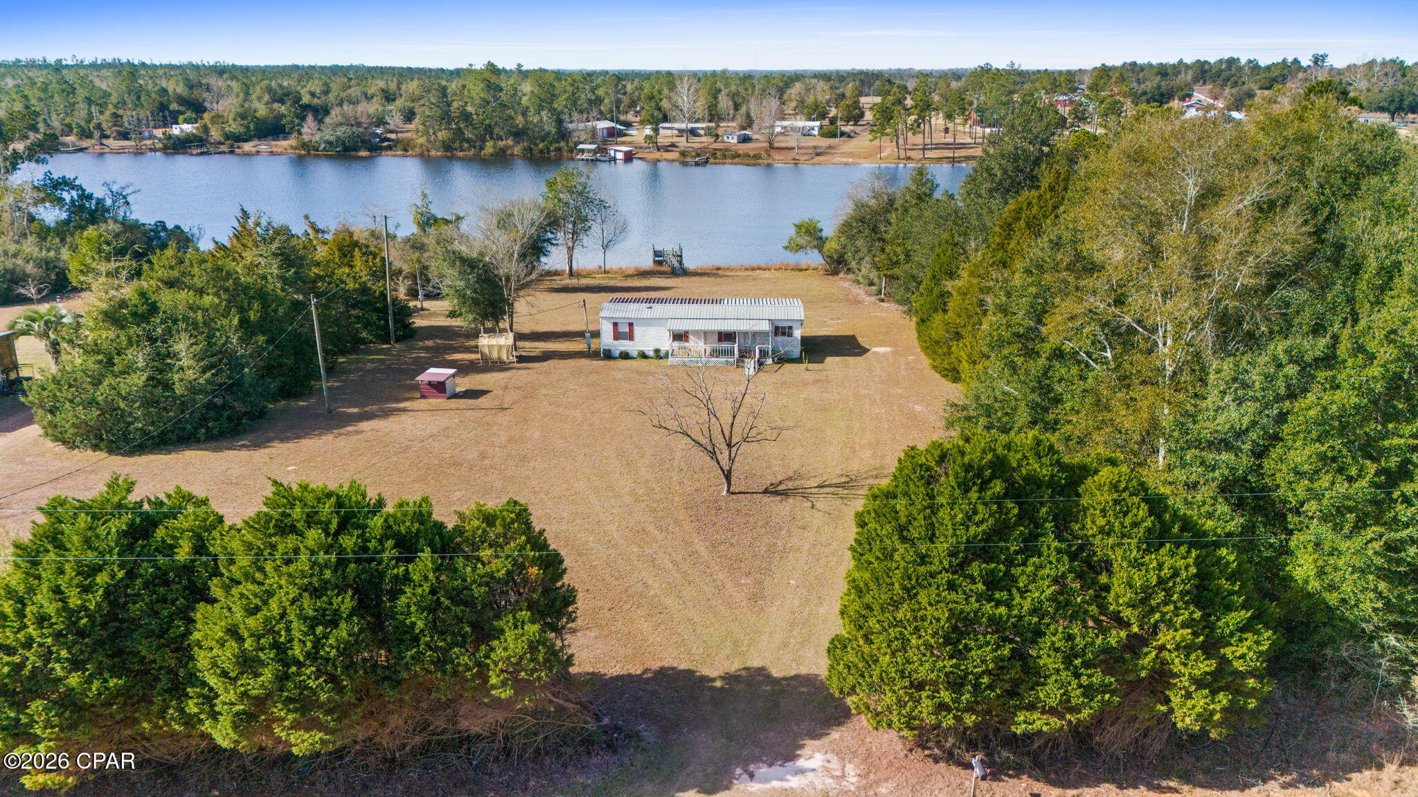 Situated on approximately 1 acre with direct water access, the property features a private dock, stunning lake views, and plenty of outdoor space to relax and enjoy Florida lake life.

The cozy 2-bedroom, 1-bath home has been thoughtfully updated with a newer roof, updated flooring, fresh paint, mini-split system, and a spacious screened porch overlooking the water. Enjoy morning coffee by the lake, sunset evenings on the dock, kayaking, fishing, and the quiet privacy this property provides.

Short-term rentals are allowed, making this an excellent investment opportunity or affordable personal retreat. Conveniently located near Marianna, Panama City, and Dothan while still offering the peaceful feeling of getting away from it all.

If you've been searching for an affordable waterfront property with charm, privacy, and income potential, this is the one.