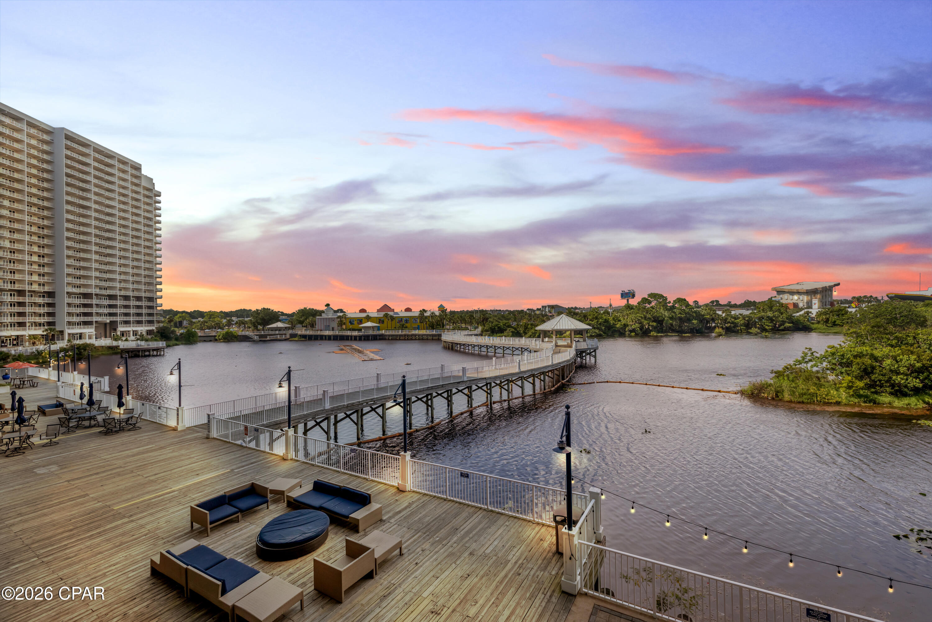 WHIMSICAL COASTAL STYLE. LAKEFRONT BALCONY VIEWS. FIRST RESIDENTIAL LEVEL CONVENIENCE.
Laketown Wharf 108 is beautifully updated, thoughtfully styled, and full of beach-inspired personality. This spacious three-bedroom, two-bathroom split-bedroom floor plan has been extensively refreshed within the past year. From the furnishings and décor to the lighting, finishes, and updated details, this residence is move-in ready and equally suited as a primary residence, second home, or vacation rental investment.
The primary suite overlooks the lake and features sliding glass door access to the large balcony. The ensuite bathroom includes double vanities, a soaking tub with decorative tile surround, a large walk-in shower, and updated fixtures.
On the opposite side of the residence, a guest bedroom and bunk room share a full bathroom, creating privacy for owners and guests alike.
A modern barn door with frosted glass panels provides privacy to the bunk room while also concealing the full-size stacked front-load washer and dryer. Throughout the residence, you'll find updated faucets, fresh paint, new lighting, ceiling fans, flat-screen TVs, and polished coastal décor with a distinctive Mermaid Cove feel. The owner's attention to detail is evident throughout, and the combination of furnishings, colors, lighting, and décor creates a residence that feels curated, memorable, and ready to enjoy from day one.
The kitchen has been thoughtfully updated with River White granite countertops, an extended granite island with beveled corners, tile backsplash, all-new stainless-steel appliances, a deep undermount stainless steel sink, and an upgraded designer faucet. Luxury vinyl plank flooring runs throughout the living areas, with tile flooring in the bathrooms.
Step outside onto the oversized balcony, fully furnished with a dining table and multiple seating areas overlooking the Laketown Wharf boardwalk, lake, and the famous nightly fountain show.
From the primary bedroom and balcony, you'll also enjoy views of the iconic WonderWorks Upside Down House and Ripley's Believe It or Not!, two of Panama City Beach's most recognizable landmarks.
Located on the first residential level, this residence offers convenient access without depending on elevators, although the elevators are located near the front door. The unit is also conveniently positioned near the owner's parking garage.
Additional improvements include a new water heater installed in 2025 and a brand-new HVAC system installed in June 2026.
This residence is owner-occupied and meticulously maintained. Some personal items do not convey with the sale.
Laketown Wharf is known for its extensive amenity package, including five pools, two hot tubs, a Gulf-view fitness center, pickleball courts, mini golf, a playground, and a 52,000-square-foot boardwalk surrounding the lake with a nightly fountain and light show. The property also offers gated beach access next door to Pineapple Willy's, on-site dining and entertainment, two parking garages, barbecue areas, pet areas, and additional resort conveniences. HOA dues are $1,065.20 per month and include water, sewer, trash, cable/TV, pest control, WiFi, and access to amenities. All information is deemed reliable but should be verified by the buyer if important.