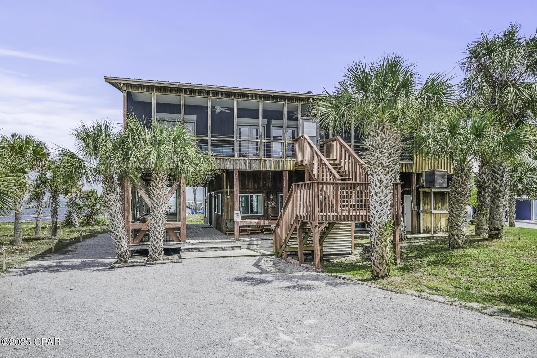 NORTH CAPE GEM ON THE BAY!   Experience bayfront living at its finest in this stunning 6-br/4-ba retreat on the bay side of North Cape. Whether you're looking for a high-end vacation rental, a serene getaway, or a forever home on the coast, this property offers an unparalleled combination of luxury, privacy & adventure. Step inside to breathtaking panoramic views of the bay, framed by a wall of windows that flood the spacious, open-concept living & kitchen areas with natural light. The thoughtfully designed split floor plan ensures privacy for all, making this home perfect for families or guests. Each level has a full kitchen perfect for entertaining. The lower level apartment has 2 bedrooms & large bathrooms featuring walk in showers with tile to the ceilings. All bedrooms have their own set of doors leading to a porch or deck. The upper level has 4 bedrooms split into 2 wings with each wing having a full bathroom. Outside, the lushly landscaped yard offers a peaceful setting to relax, while the fire pit provides the perfect spot to gather. For those who love the water, the 500-foot private dock with a boat lift is a dream come true--perfect for boating, fishing, crabbing, or simply soaking in the beauty of the bay. Spend your days kayaking, paddleboarding, or windsurfing right from your backyard, or explore the nearby sandbars. An outdoor shower, featuring hot & cold water, is convenient to wash away the days adventures. Access to the Cape's scenic paved path, ideal for biking or walking, and is just a short stroll to the Gulf-side beach, where you can take in breathtaking sunsets. Whether you're starting your day with a peaceful paddle at sunrise, fishing off your private dock, or ending the evening with s'mores by the fire, this gem of a home is a rare opportunity to own a slice of paradise. Nearby Port St. Joe adds charm with its historic downtown featuring unique boutiques & seafood restaurants. Call & schedule your private showing today to LIVE THE BEACH LIFE!