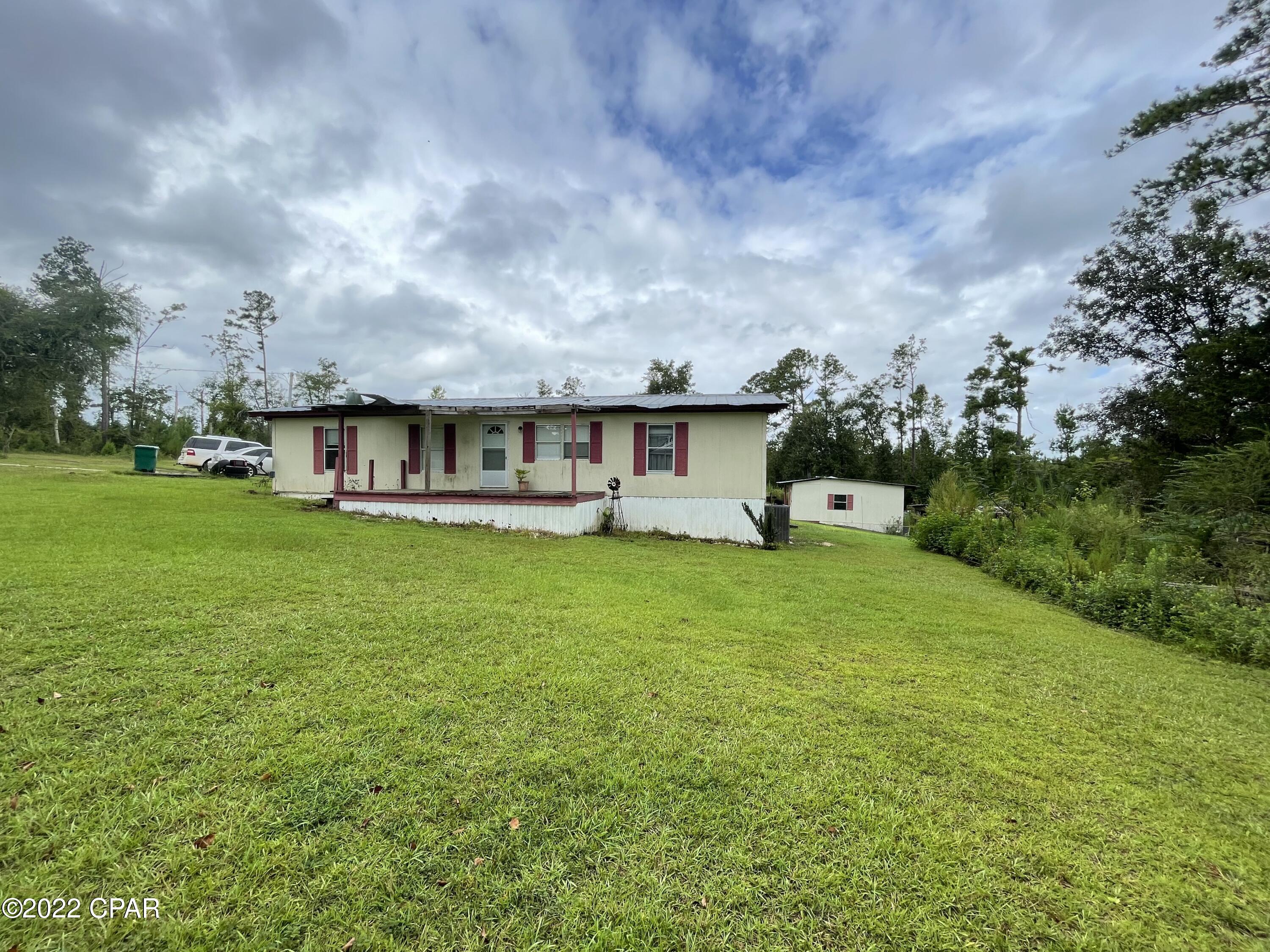 3/2 on 1.5 acres right outside of the City of Marianna. Home needs a little TLC but has had many improvements already. Living area is open concept with a split floor plan. There are large covered decks on the front and back of home along with a couple of outbuildings. Another 2 acres with well and septic available for sale next door!