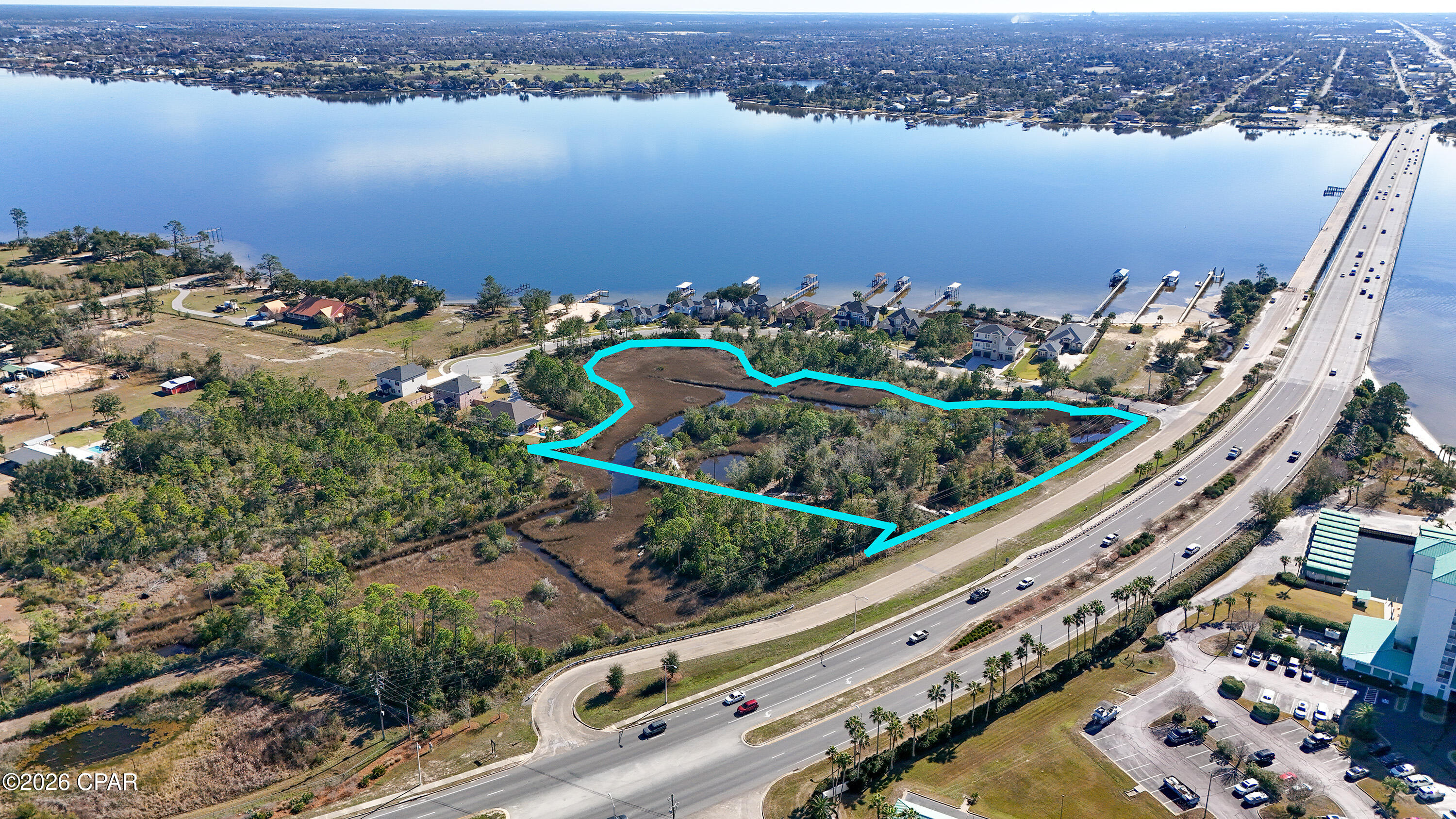 An exceptional opportunity to own a truly stunning property offering views of the bay, marsh, and bridge! Encompassing 4.58 acres on the northeast side of Bailey Bridge, this parcel is ideally suited for a private estate or a planned development. The land has been partially cleared and surveyed with the intent to divide it into two lots, allowing for the potential to build a duplex on each parcel, or pursue a larger residential or mixed-use project. Zoned for mixed use, the property allows for both residential and commercial development, with the possibility of constructing up to 11 townhomes. Water and sewer lines already run through the property, adding convenience and value for future development. Natural features include stunning wetlands and a pond, enhancing the beauty and privacy of the property. Located just a short distance from shopping, dining, and medical facilities in Lynn Haven and Panama City, and only minutes from the beach and Tyndall Air Force Base, this property offers a rare blend of natural beauty, flexibility, and prime location. This listing is for the purchase of the entire parcel—an outstanding investment with endless potential!