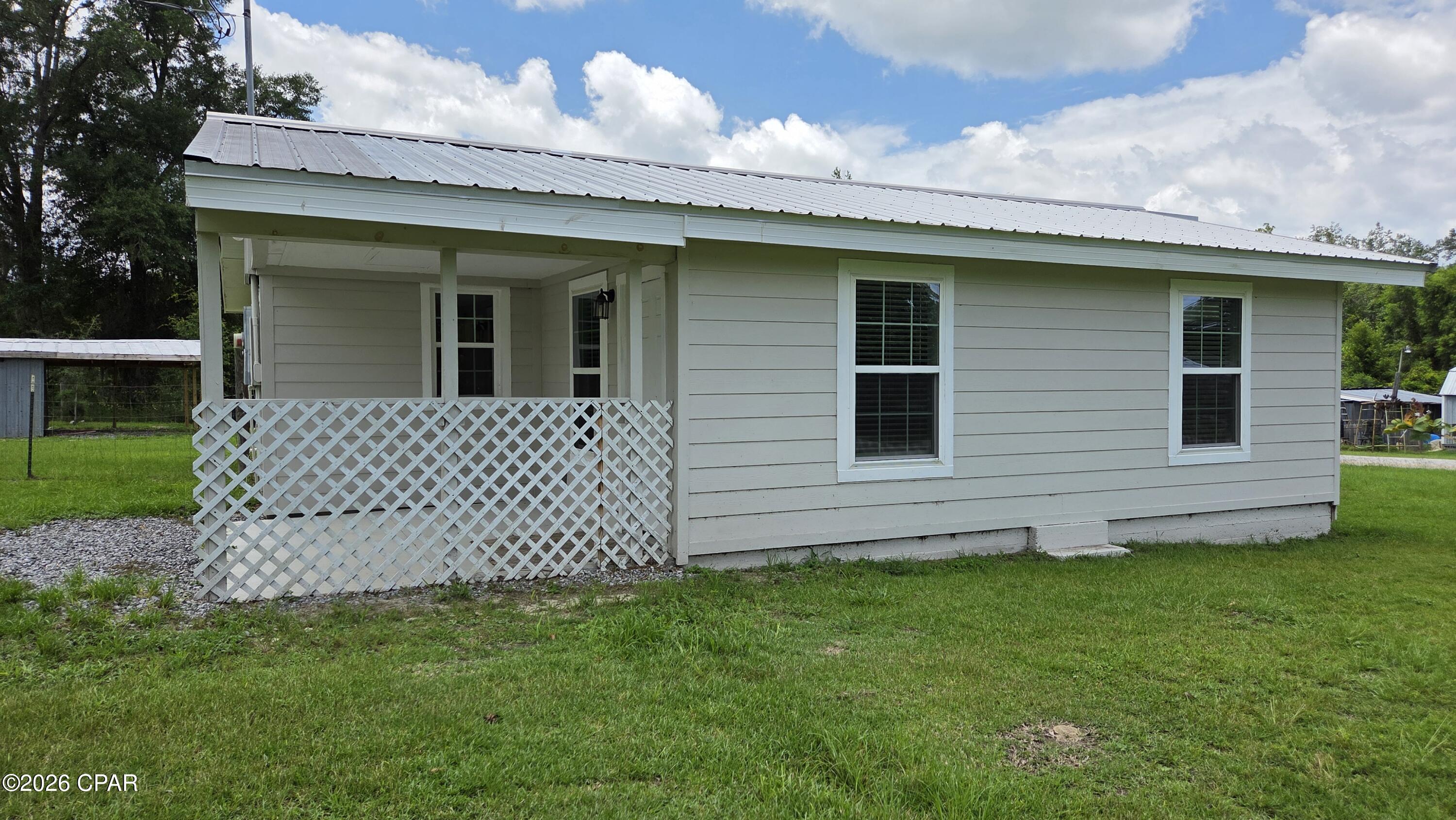 This move in ready 3 bedroom, 1 bath Florida cottage sits on 1.14 acres just outside of city limits. Recent improvements include a newer metal roof, updated bathroom, plumbing, electrical, water heater, flooring, and kitchen appliances. The home also features upgraded windows. The eat in kitchen offers an island and ample cabinet space. Enjoy the privacy and outdoor space this property provides, complete with a partially fenced in yard and a shed for storage. Conveniently located near I-10 for easy travel and commuting. Florida Caverns State Park is just 12 minutes away, making it easy to enjoy hiking, kayaking, and one of Florida's most unique natural attractions. This home is ready for it's new owner-come see it today!