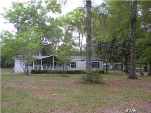 Serenity is yours in this 4 bd, 3 ba, mobile home with over 2000 sq ft on 5 acres with 3 large covered porches, 3 sheds for extra storage and a 2 car carport. Stepping inside you will find a roomy living room with fireplace, split bedroom floor plan, kitchen with an island and lots of cabinets, two of the bedrooms have a Jack n Jill bathroom with dual sinks between them so no fussing. Your master suite is roomy with a walk in closet and double doors leading into your master bathroom with double vanities so no fussing there either. Take a look at this one ASAP as you will be surprised.