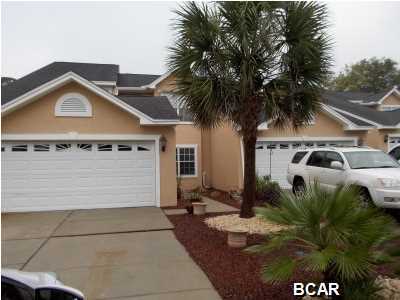 This is a very large townhouse located on the 6th hole of Panama Country Club in Lynn Haven, FL. This townhouse has beautiful hardwood floors, tall ceilings in great room with very nice crown molding, real wood cabinets in kitchen, kitchen island, gas fireplace and tons of storage. There is a wonderful screened in patio perfect for watching the golfers, sipping wine and just totally relaxing. Exterior has just been repainted with Elastomeric Paint. The master bedroom/master bath are on the main level and there are 3 large bedrooms and one bath on the 2nd floor. It is an end unit and has an easement across the street so no house will ever be built there. Must see to believe how spacious this townhouse really is!!