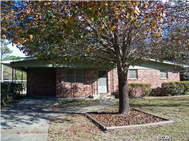 Lovingly maintained all brick home on large corner lot in Lynn Haven. Very, very good condition. Roof replaced in 2004. Original hardwood flooring (even under the carpeting in the living room). This 3 bedroom, 1 bath home is sure to impress you. Huge enclosed porch. Large laundry room off of the back porch. Double corner lot, landscaped and very pretty. Home has an attached carport, additional carport in the side yard (accessed by double gates). Don't miss your opportunity to view this lovely home. (all sizes approximate and taken from public records, buyer to verify any details buyer deems important).