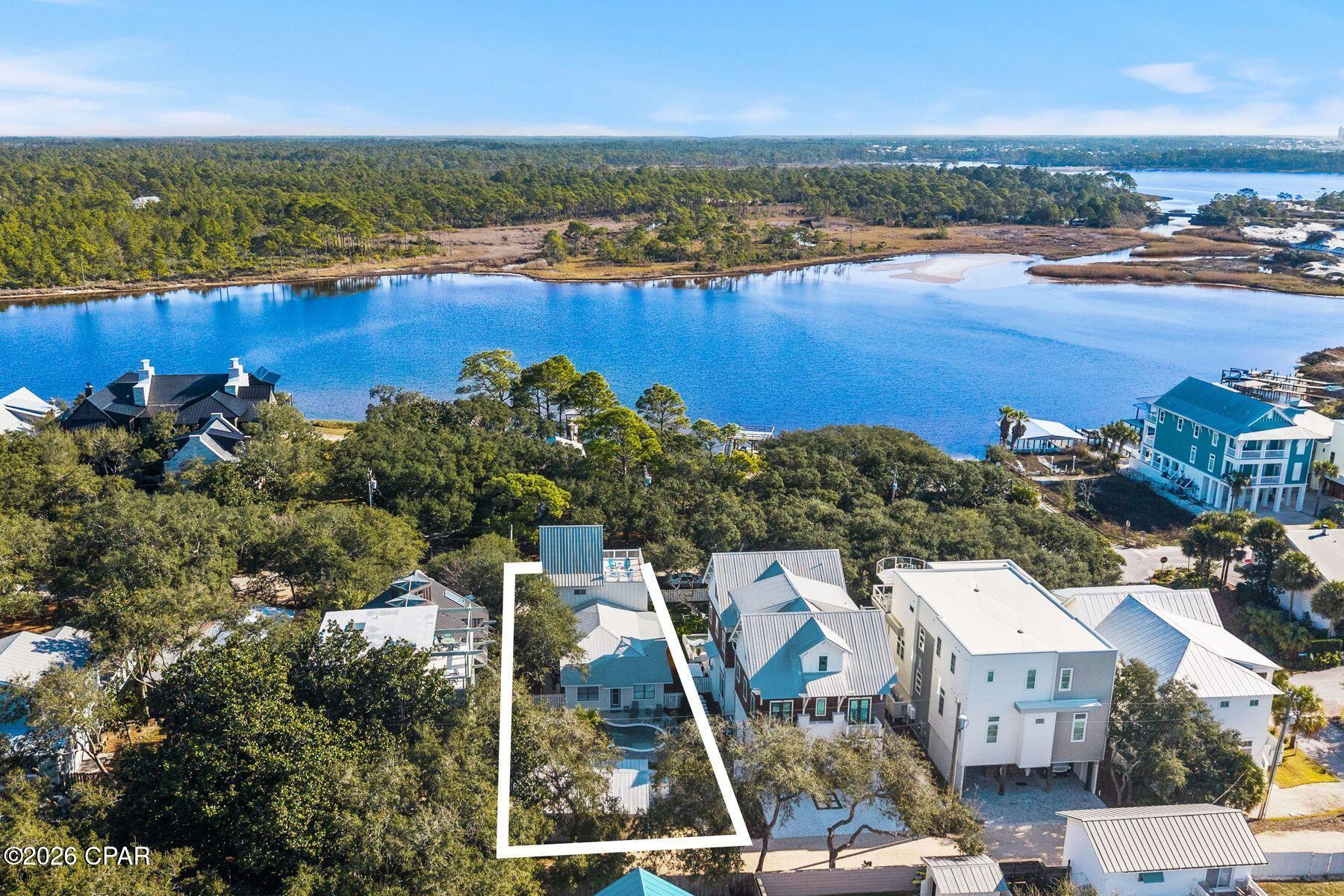 Timeless Grayton Beach character meets thoughtful modern renovation in this rare dual-residence offering just steps from Western Lake, the shoreline, and the heart of one of 30A's most storied beach villages. Originally built in 1970 and extensively reimagined, the property pairs a gracious main home with a fully detached private cottage, creating flexibility for hosting, multigenerational living, or income potential without sacrificing privacy or charm.

The main residence spans approximately 2,910 square feet with five bedrooms and four-and-a-half baths across three levels. Recent updates include a fully redesigned kitchen, renovated bathrooms, fresh interior paint, new flooring, updated wiring and plumbing, two HVAC systems, new appliances, and a new roof. From the inviting front porch, morning coffee is enjoyed with tranquil views toward Western Lake. Inside, the first floor opens to a generous living and dining area that flows seamlessly into the kitchen, which offers ample space for an island and connects to a comfortable sitting or game room. A mudroom off the kitchen adds a half bath, a full-sized laundry, and direct access to the side yard for grilling.

Two first-floor bedrooms feature updated ensuite baths, while a rear hallway leads directly to the backyard. Upstairs, the second level offers two additional bedrooms and two full baths. The third floor serves as a flexible retreat or bedroom, highlighted by a striking wood A-frame ceiling with access to the large balcony.

The detached cottage provides approximately 560 square feet with one bedroom, one full bath, a family room, a full kitchen, a laundry room, an outdoor shower, and a separate entrance. With a new roof and alley access, the cottage allows easy movement to the beach, lake, and dining while remaining discreetly set apart from the main home.

Outdoor living is equally compelling, with a spacious backyard ready for relaxed afternoons, a newly added private pool, curated hardscape, and lush landscaping. After a day on the water, rinse off at the outdoor shower or unwind in one of several private seating areas. Parking is generous with a paver driveway, additional front parking, and two rear spaces for a total of seven. Accessibility has been carefully considered with a ramp on the north side and a fully accessible first floor, including the primary bath.

Both residences may be rented separately or together, offering exceptional versatility. Positioned moments from Western Lake, two beach accesses, and iconic spots like The Red Bar, Chiringo, and AJ's Grayton Beach, this is a rare opportunity to own a true Grayton Beach classic where coastal history, modern updates, and an unbeatable walkable setting come together with ease.