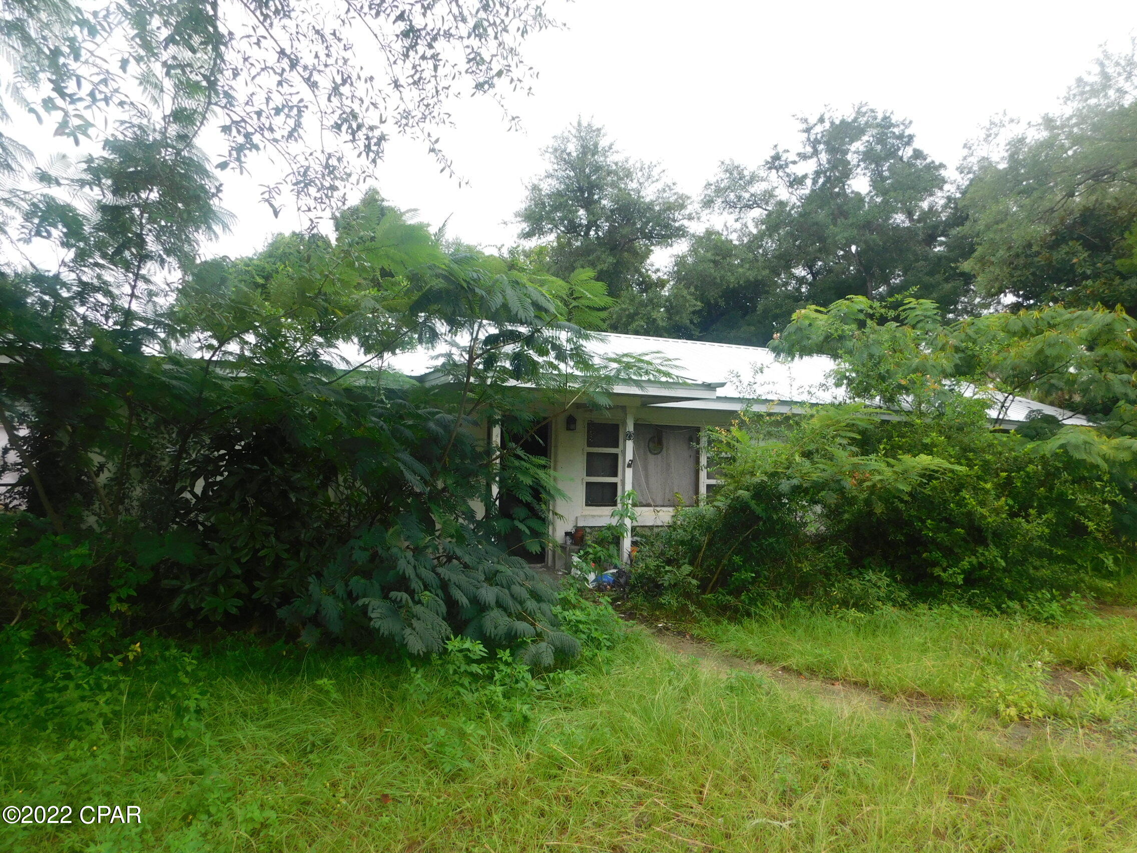Larger older three bedroom one bathroom block home with bonus room, all needing some tender loving care offered as is.  The home has a a  one car detached one car garage currently used as living space that is not reflected in the heating and cooled space. The location is near Tyndall Air Force Base, Highway 98 and walking distance to the bay,  All sizes are approximate or taken from other sources please verify accordingly.  Seller is planning on only taking the items in the living room and garage.