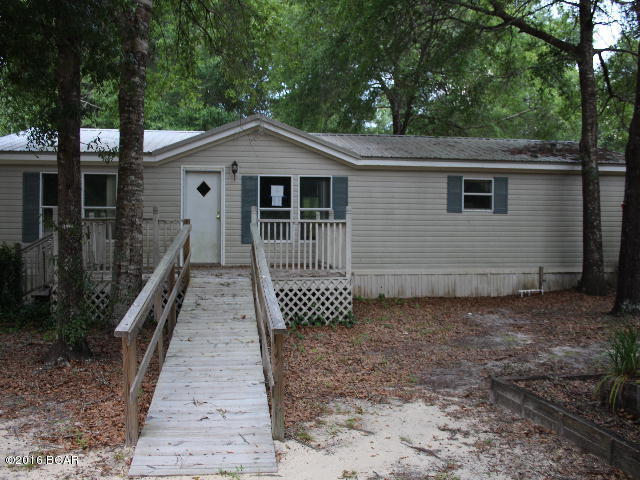 * PRICE REDUCED * 5 acres with chain link fencing and an interior fence around this lovely doublewide mobile home.Home has nice features that include a large living room with fireplace, split bedroom design and lots of room. The back yard features a large wood deck just right for entertaining and cookouts! There is a detached 2 car garage and a 2 car detached carport. If you like country living you will love this place! Conveniently located north of Panama City, home of some of the worlds most beautiful beaches!